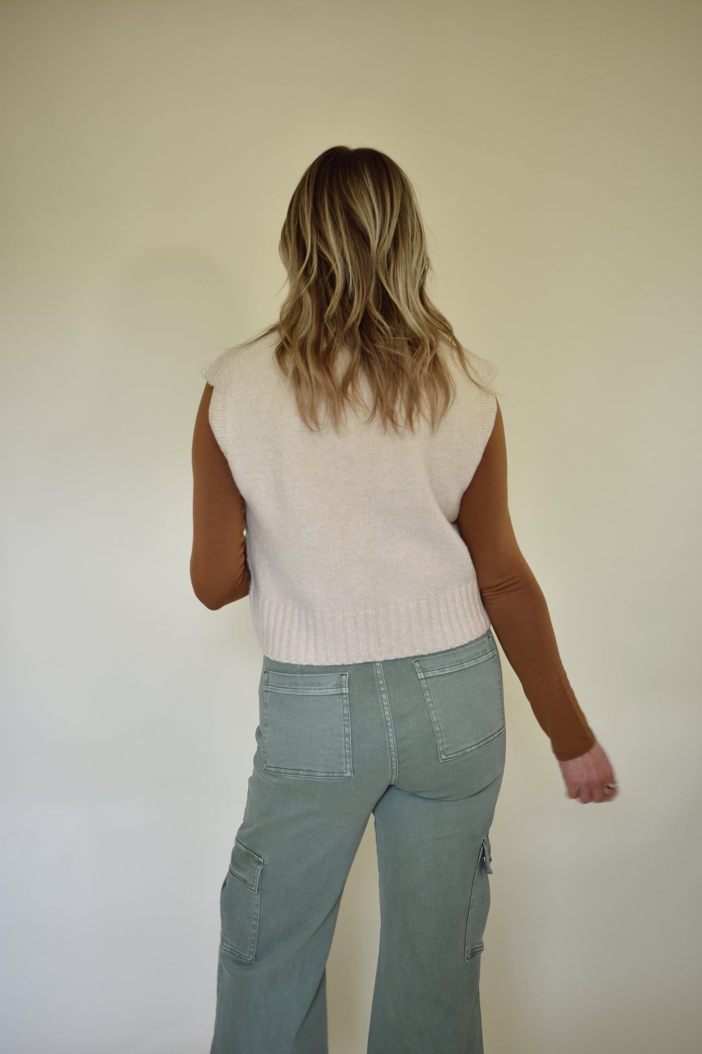 V neck sweater vest - slightly cropped, loose fit. Wide ribbed detail on neckline, sleeves and hem. Cream colored.