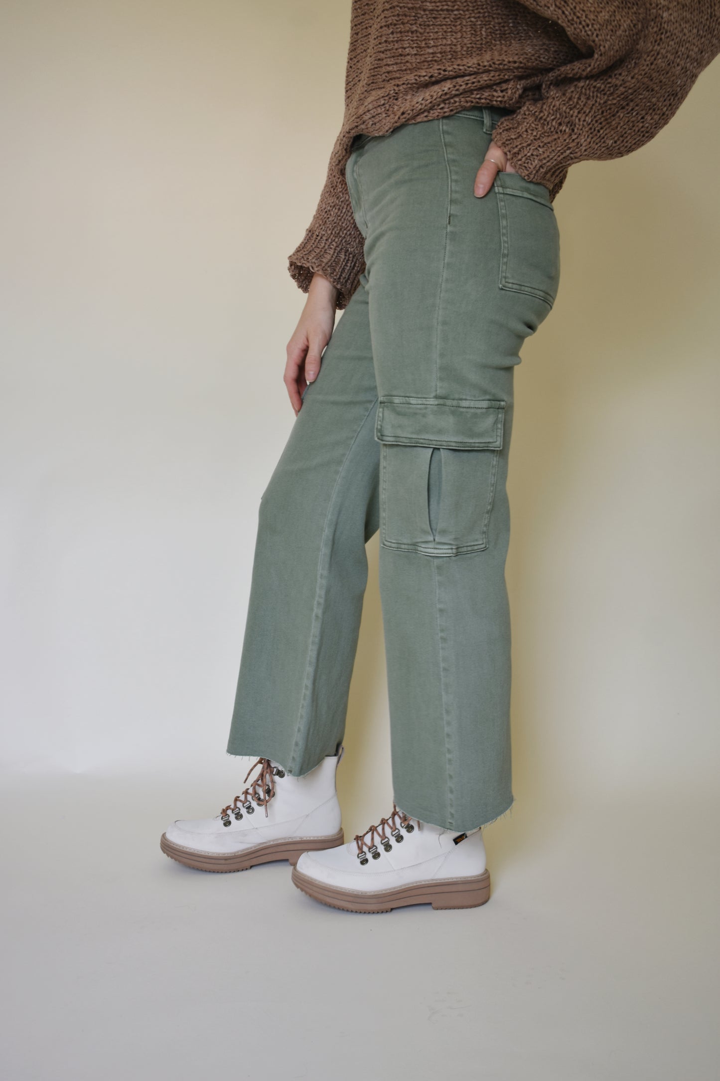 Wide leg cargo pants with pockets on side with flap and on the back. Button enclosure with belt loops. Raw hem. Sage green color.