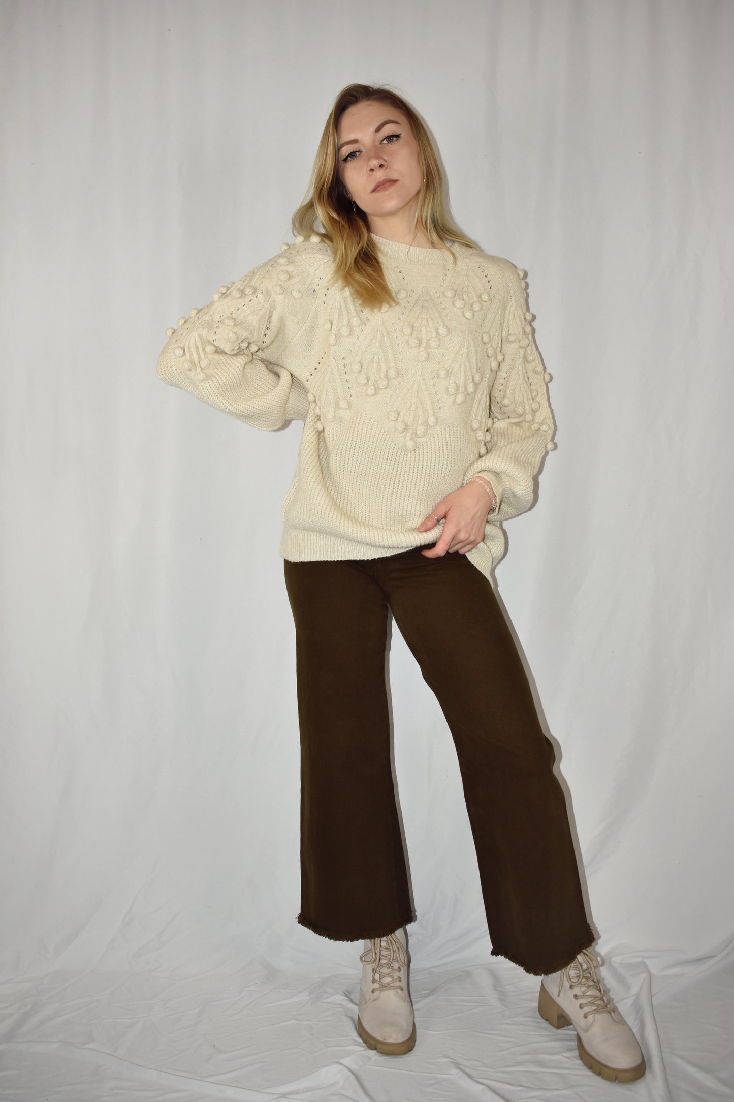 oversized knit full length cream colored sweater with pom pom detailing on the top half. slight balloon style sleeves.