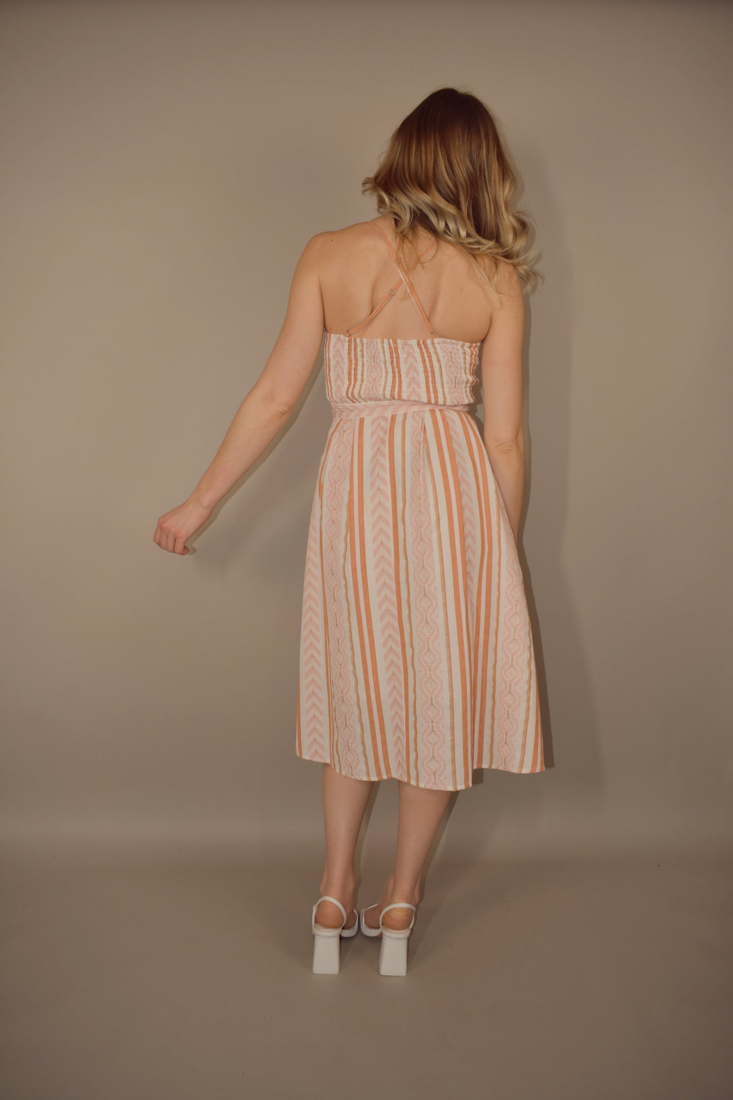 Stripe and chevron patterned midi dress with fitted bodice and zip enclosure. adjustable spaghetti straps. lined and a little bit of swing to it. slight v in front. smocked upper back. criss cross straps