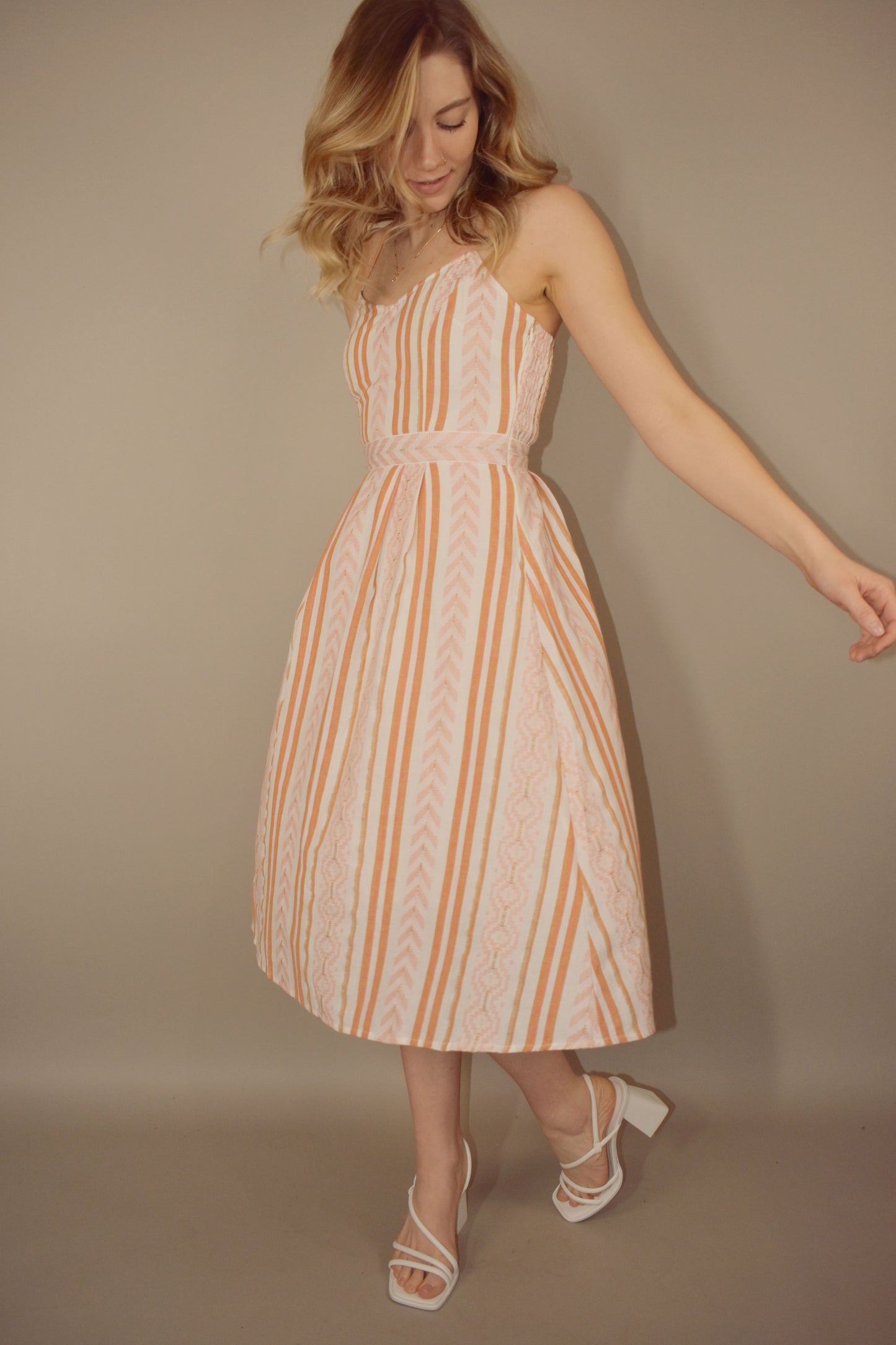 Stripe and chevron patterned midi dress with fitted bodice and zip enclosure. adjustable spaghetti straps. lined and a little bit of swing to it. slight v in front. smocked upper back. criss cross straps