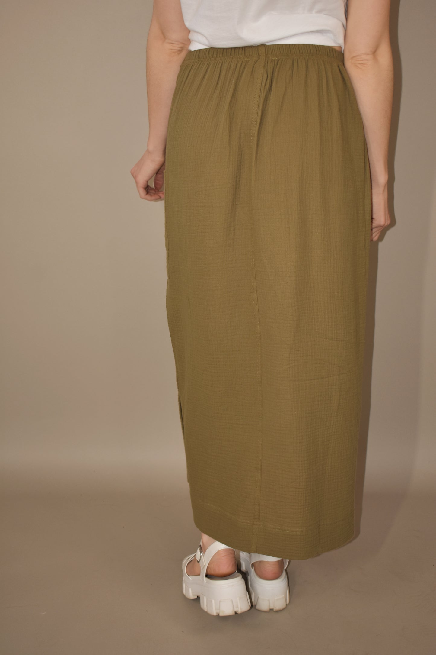 olive double gauze fabric midi skirt. side slit and patch pocket on the same side as the slit. seam down the front. drawstring waist. super soft.