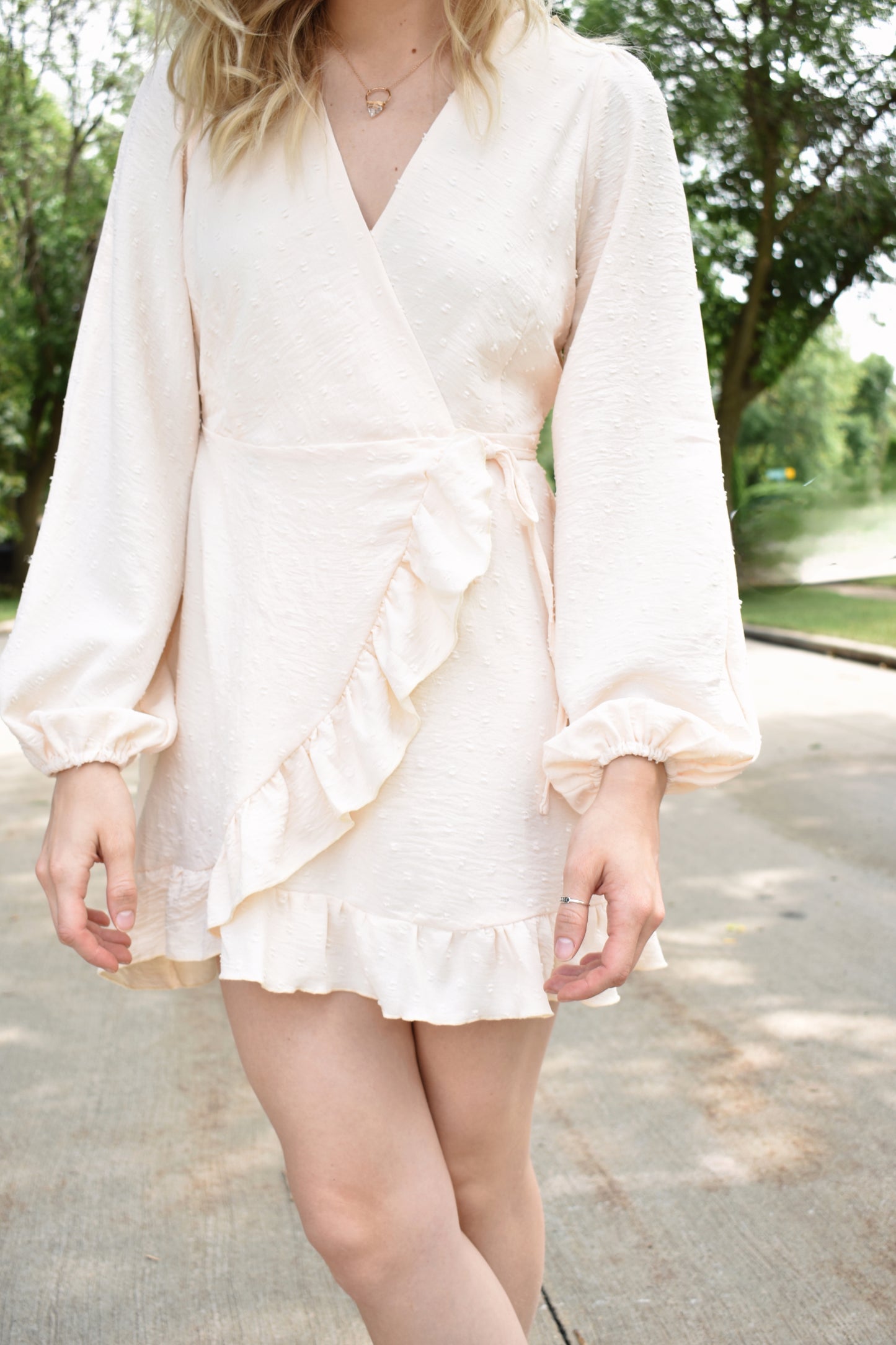 Cream swiss dot textured mini wrap dress with long billow sleeves and ruffled hem