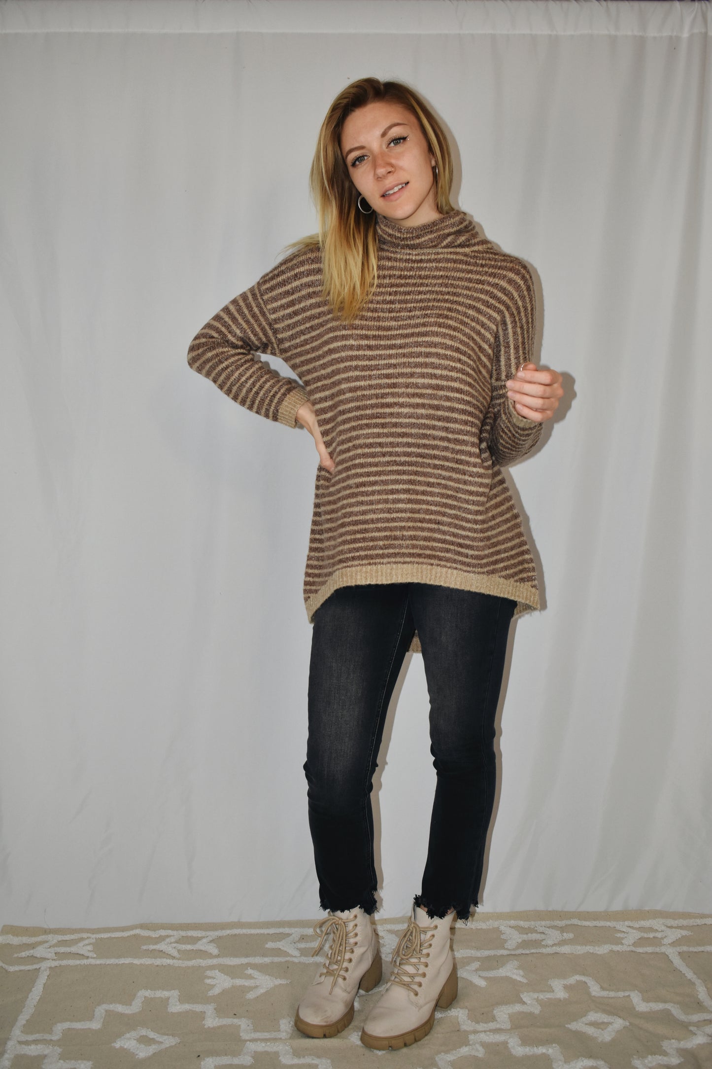 Pullover turtleneck striped sweater. Drop shoulder long sleeves, ribbed hem and sleeve cuffs, and high-low rounded hem. Dark mocha and taupe color.
