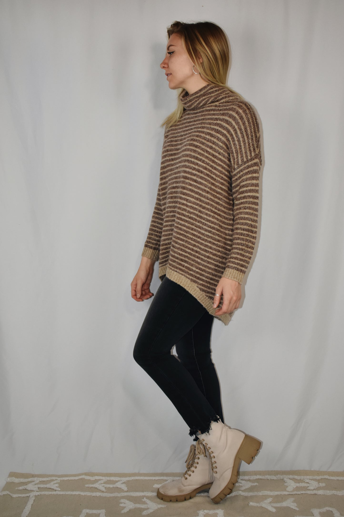Pullover turtleneck striped sweater. Drop shoulder long sleeves, ribbed hem and sleeve cuffs, and high-low rounded hem. Dark mocha and taupe color.