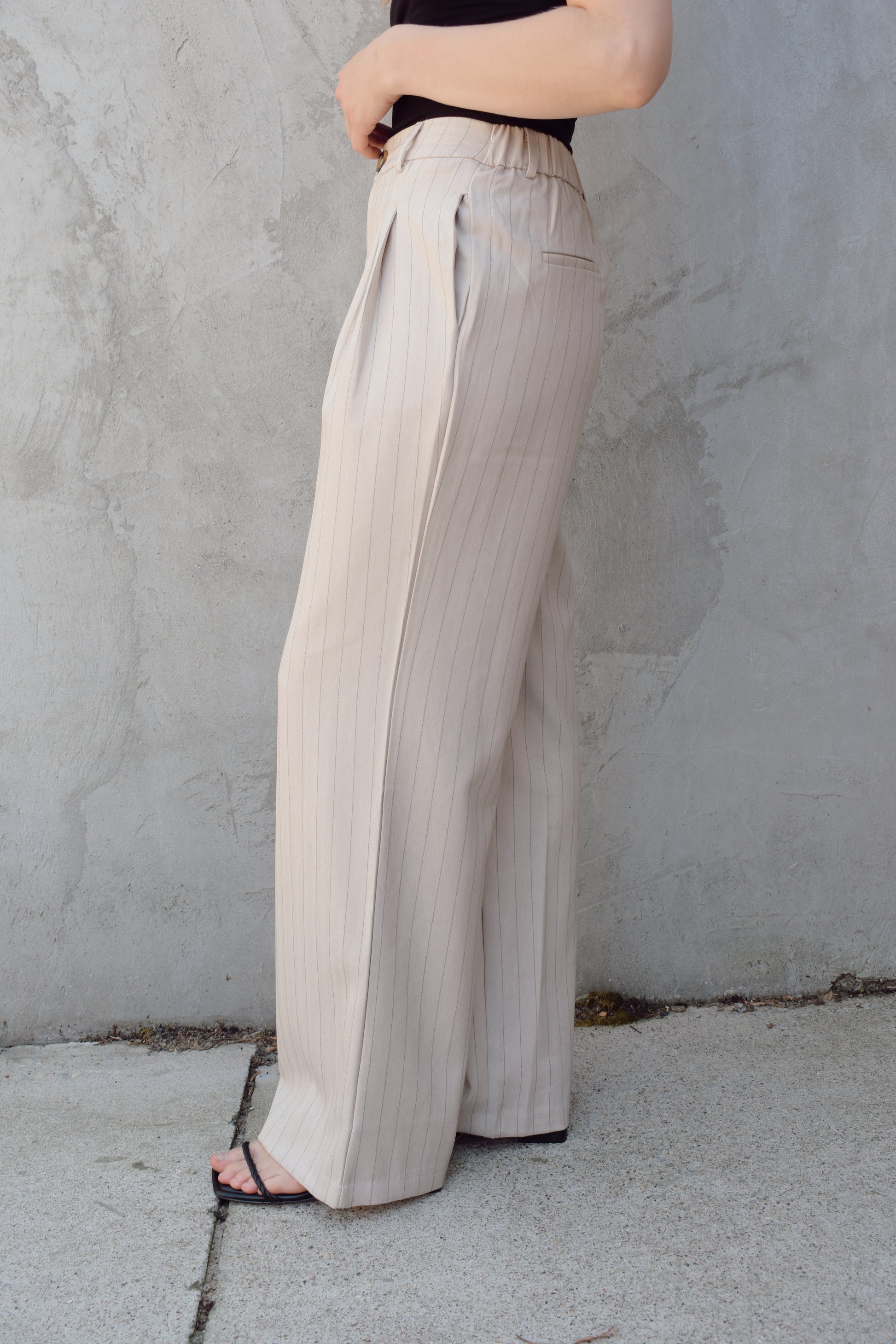 vertical pinstripe trousers with front pleats, pockets, zip and button enclosure, has beltloops, fake back pockets, elastic on back of waistband, full length