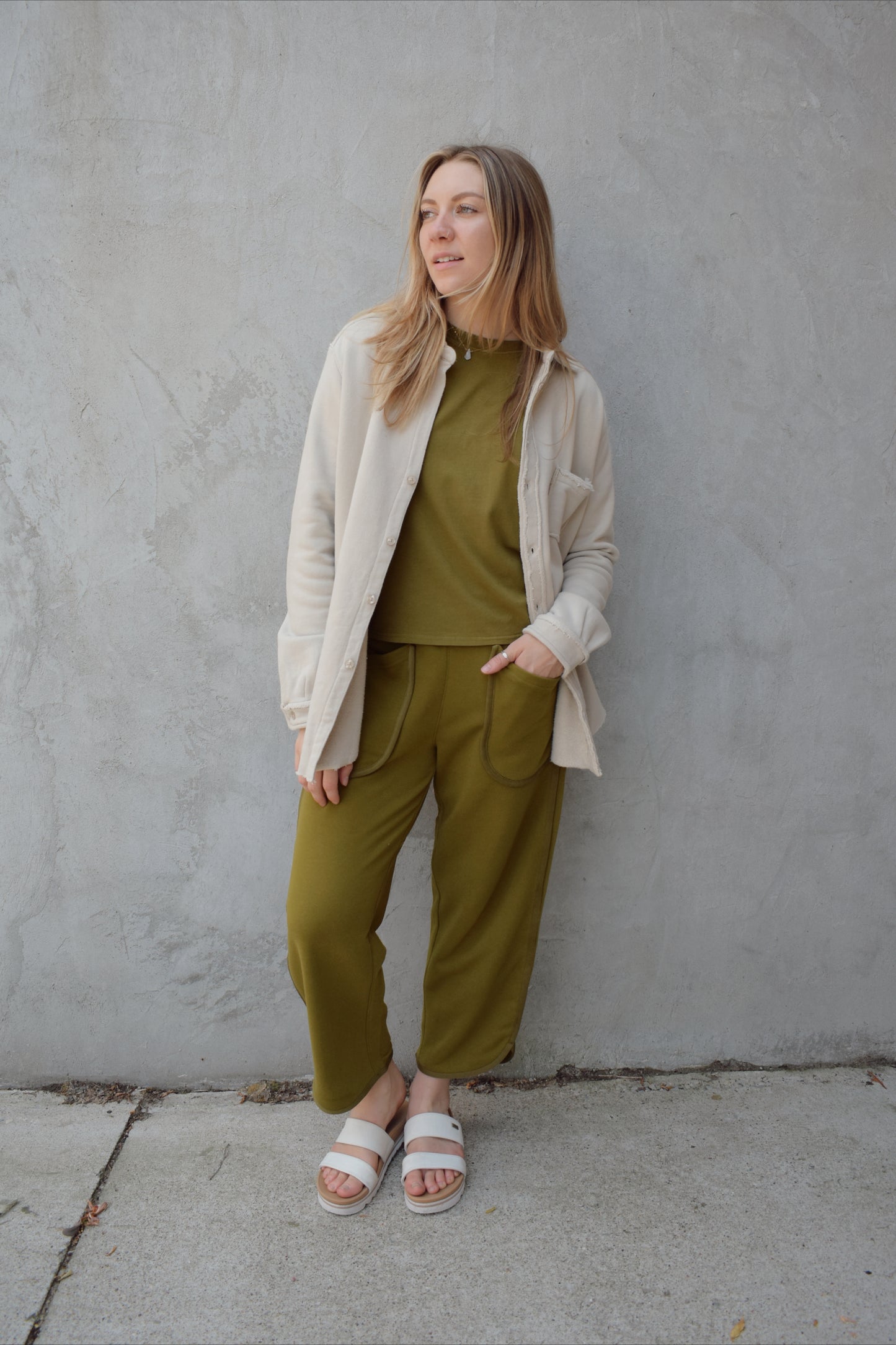 lounge pants with relaxed cropped fit, curved hem, oversized front bucket patch pockets, elastic waistband, seam detailing along sides, athleisure