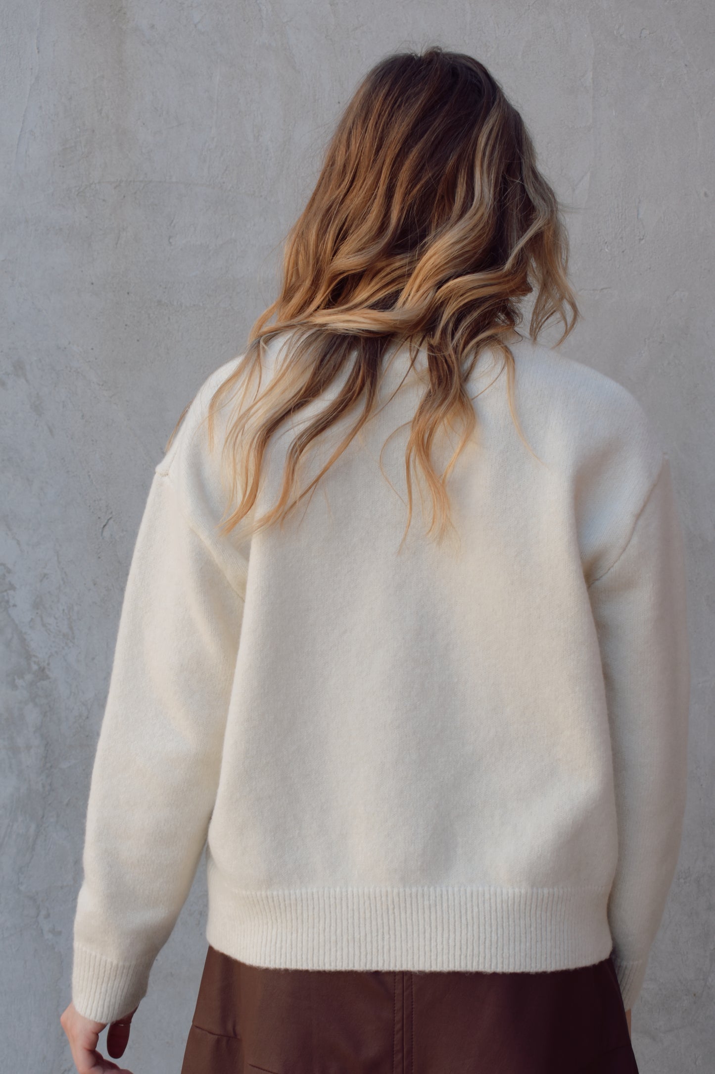 cream colored crew neck sweater relaxed fit full length with cowboy design in brown on front ribbed cuffs hem and neckline