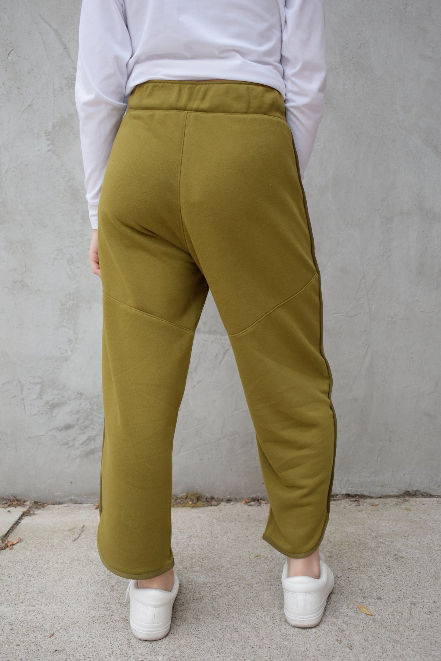lounge pants with relaxed cropped fit, curved hem, oversized front bucket patch pockets, elastic waistband, seam detailing along sides, athleisure