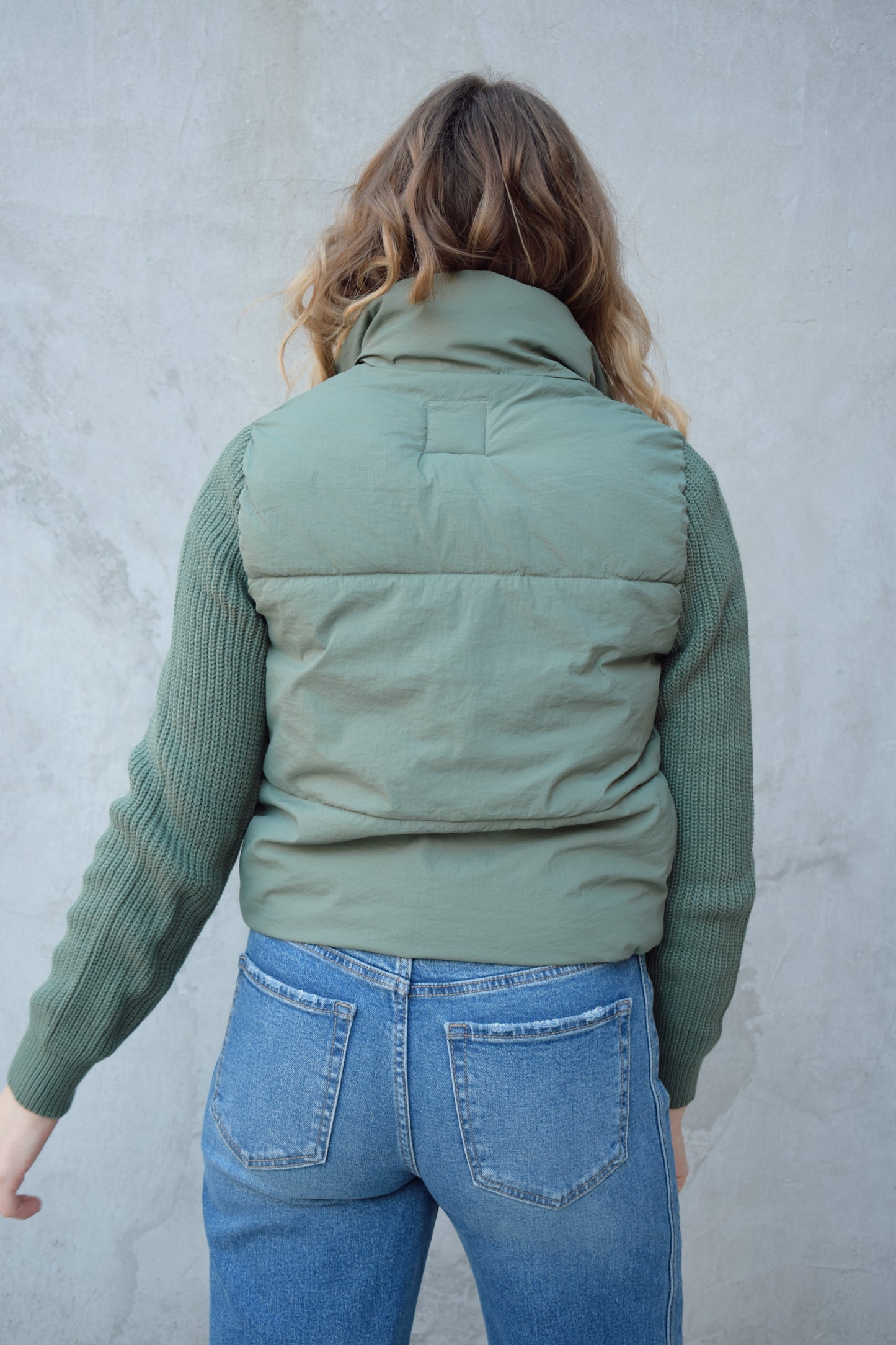 blue green puffer jacket with ribbed knit sleeves, zip and snap front enclosure, has double collar with both materials, has pockets, sinch band at hem