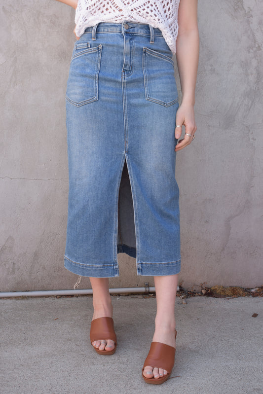 utility stretch denim midi skirt with front slit medium wash large patch pockets on front with angled entry has back pockets and belt loops zip and button enclosure