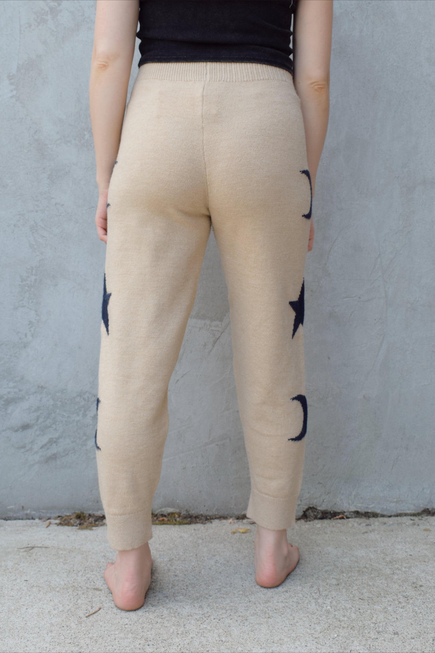 cream knit joggers with slightly elastic wide waistband, high waisted, moon and star design on sides of leg, relaxed fit, no pockets