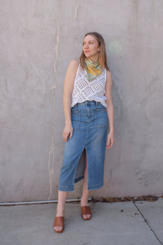 utility stretch denim midi skirt with front slit medium wash large patch pockets on front with angled entry has back pockets and belt loops zip and button enclosure