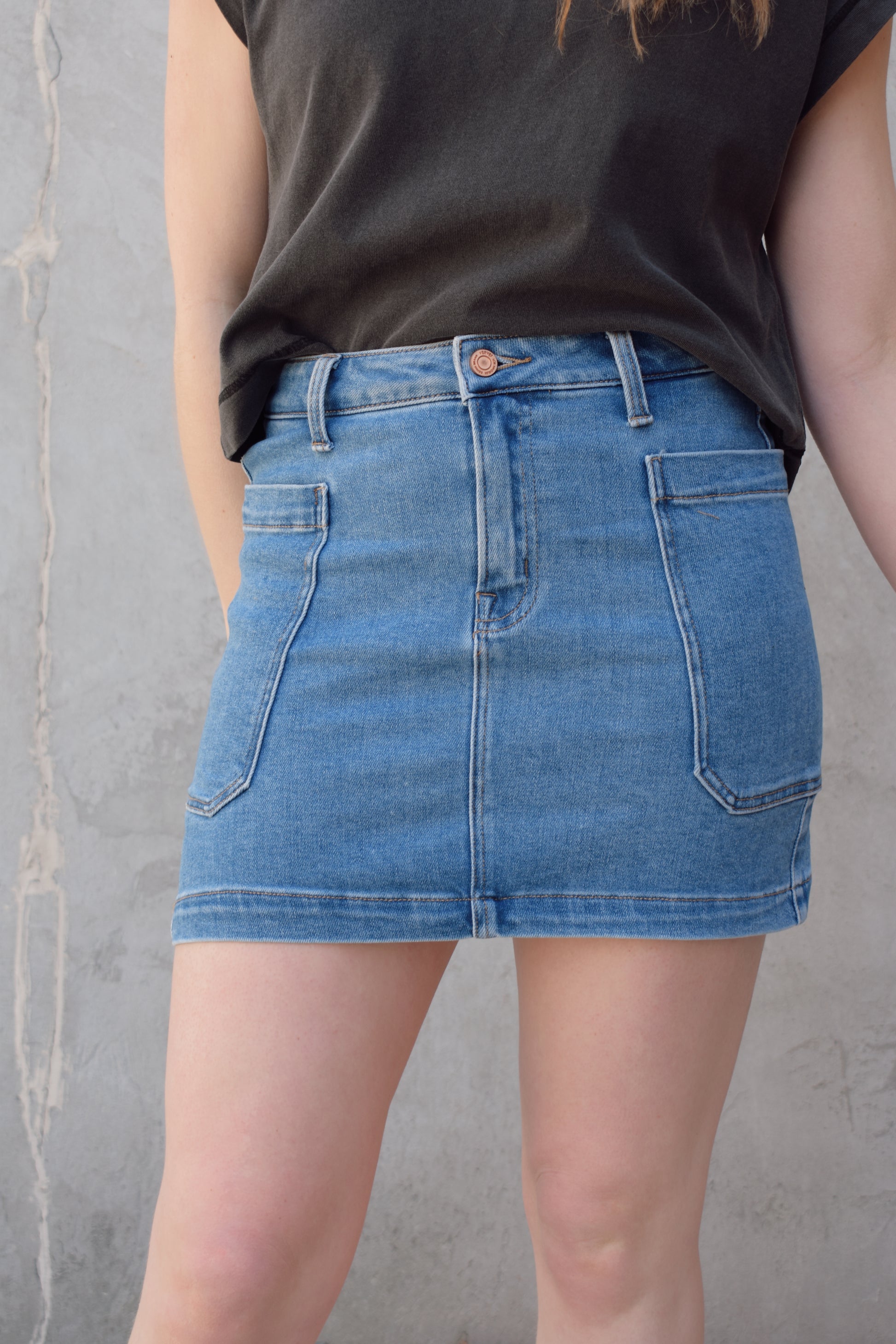 mini medium wash denim skirt stretch denim with big side patch pockets zip and button enclosure no distressing has beltloops