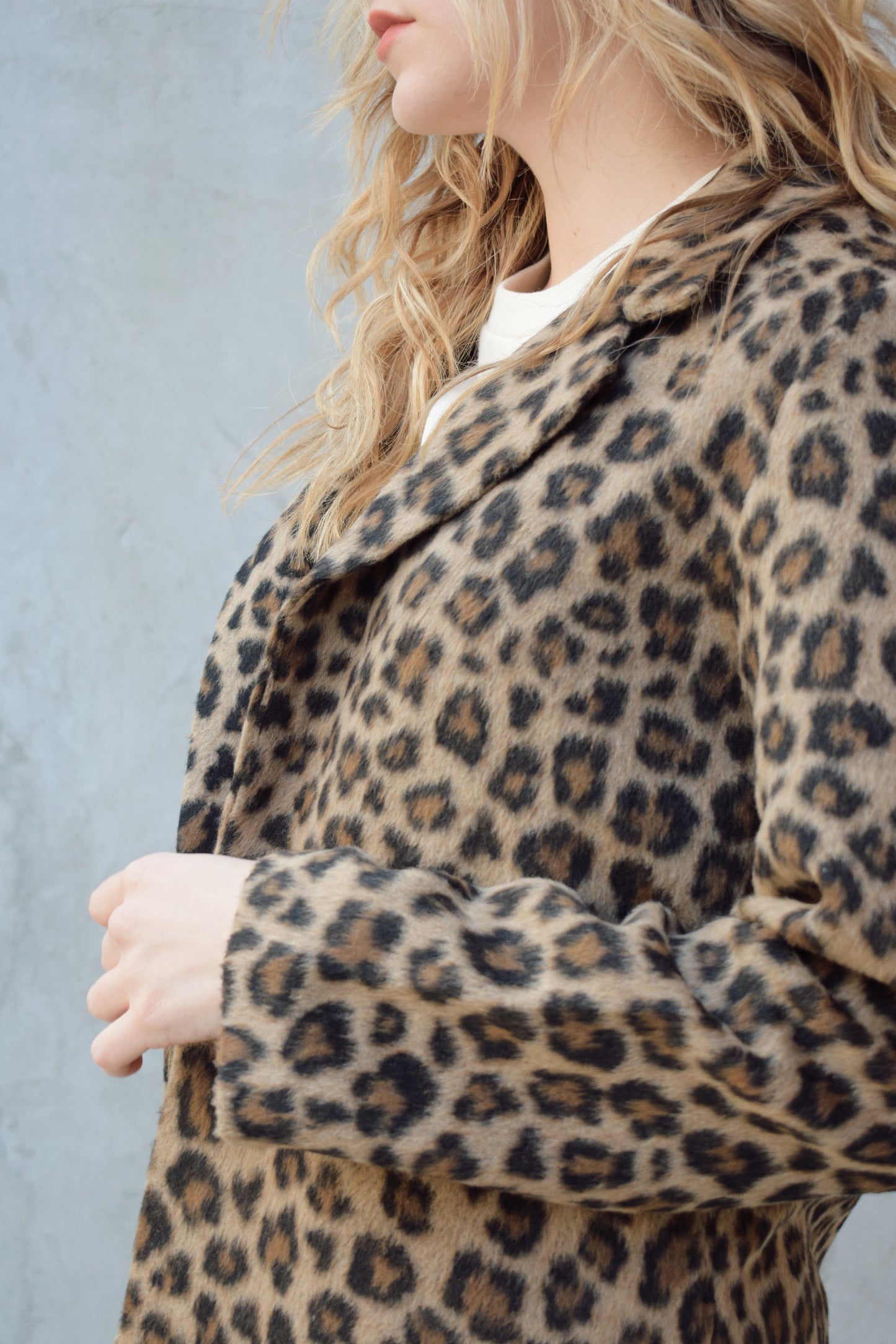leopard print coat with collar and singular button enclosure has pockets hits just above the knee