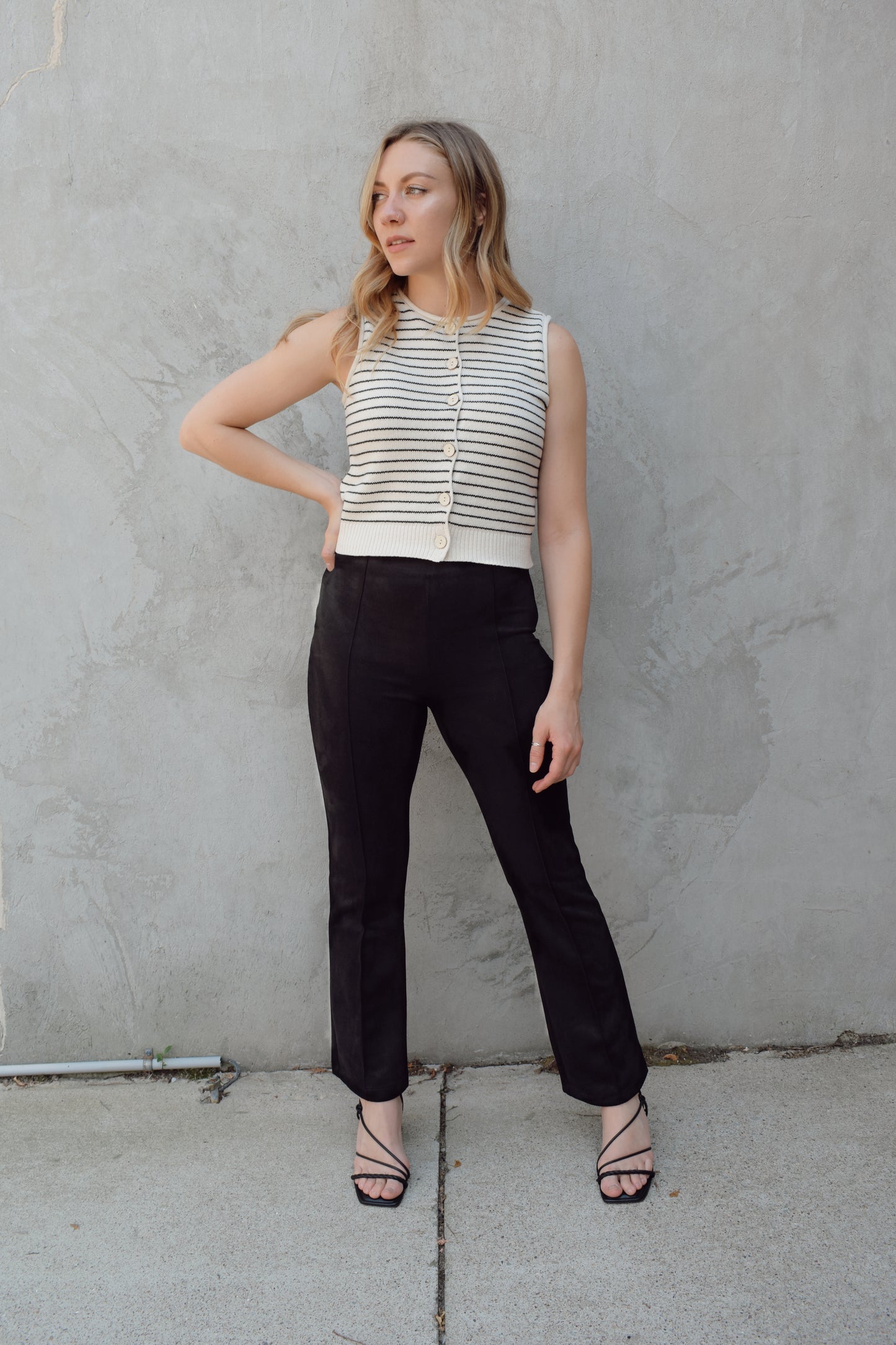 black faux suede pants with a slight cropped kick flare, raised seam detail along front of pant legs, zip side enclosure, high waisted