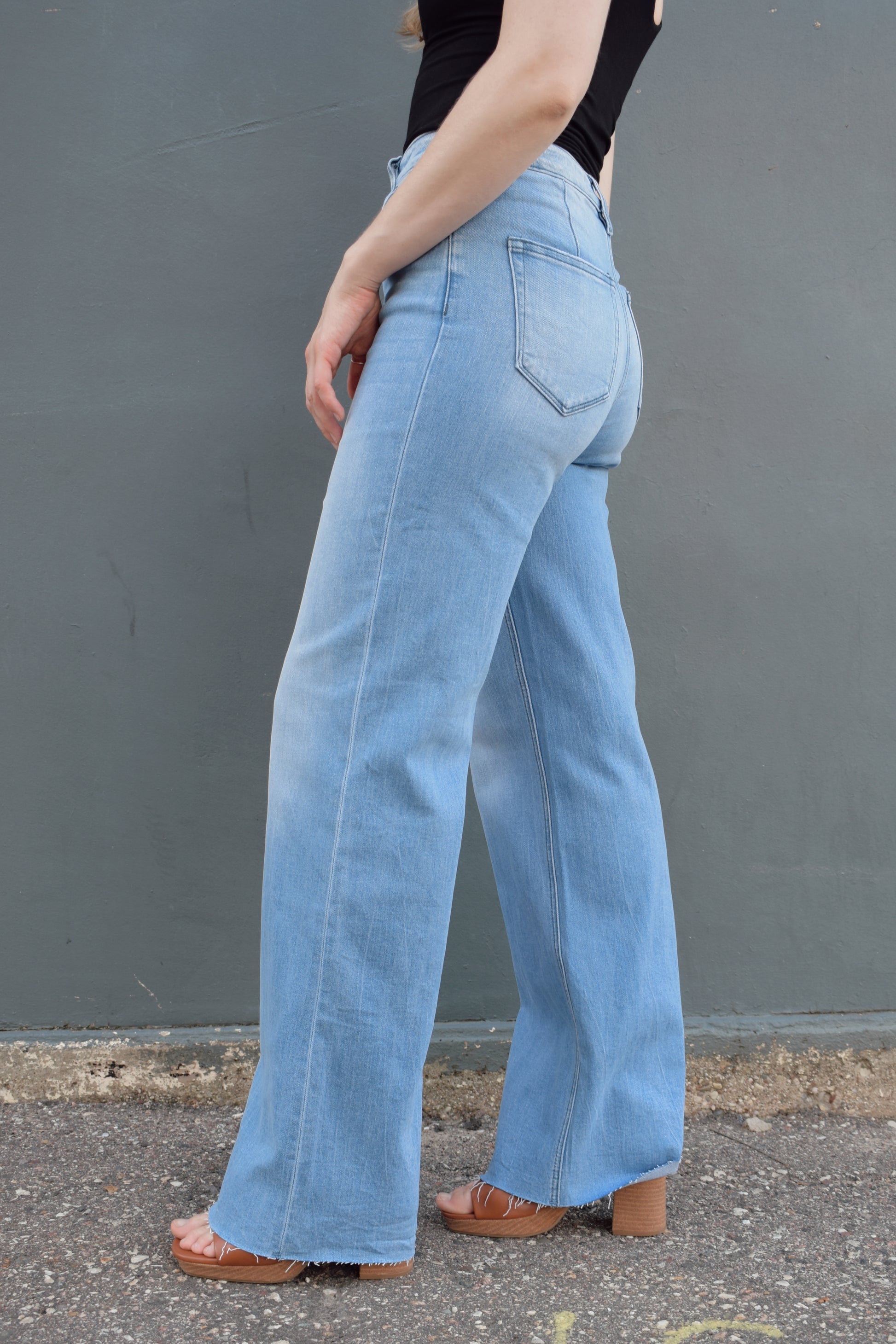 high rise full length wide leg jeans stretch denim raw hem light wash no distressing or holes, retro seam detailing above back pockets, zip and button enclosure