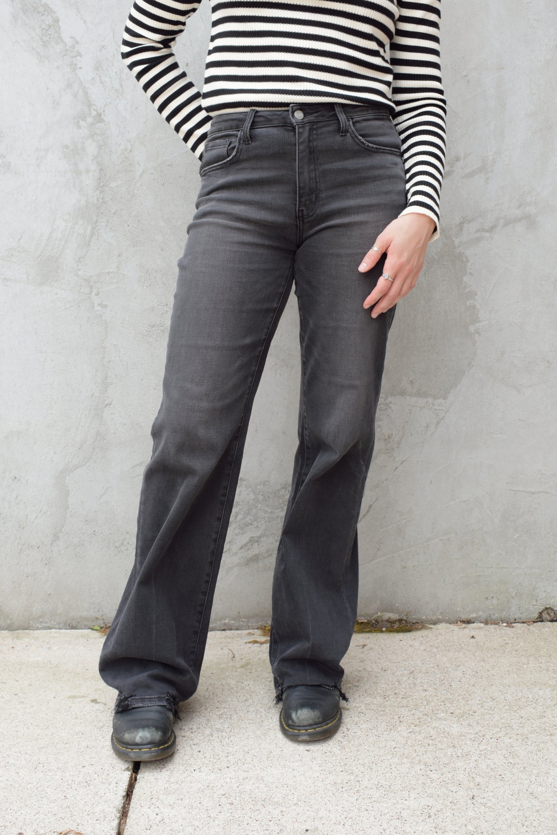 high rise washed black wide leg flare jeans full length stretch denim distressed hem but no holes zip and button enclosure has beltloops has front and back pockets