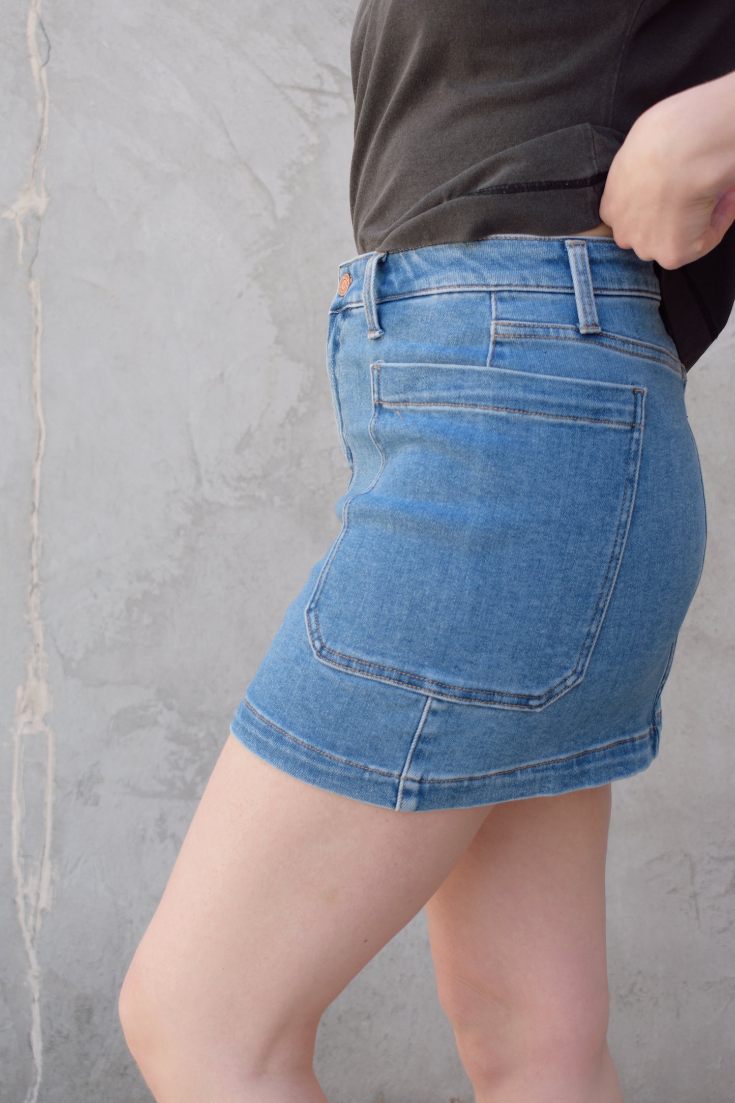 mini medium wash denim skirt stretch denim with big side patch pockets zip and button enclosure no distressing has beltloops