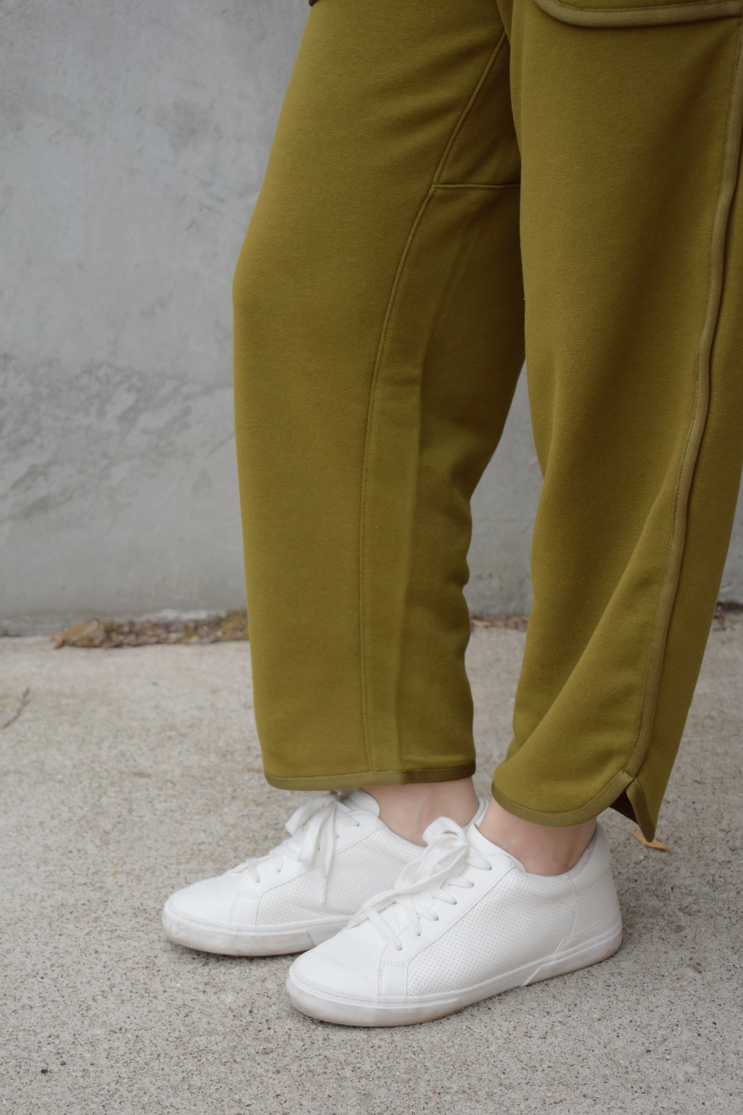 lounge pants with relaxed cropped fit, curved hem, oversized front bucket patch pockets, elastic waistband, seam detailing along sides, athleisure