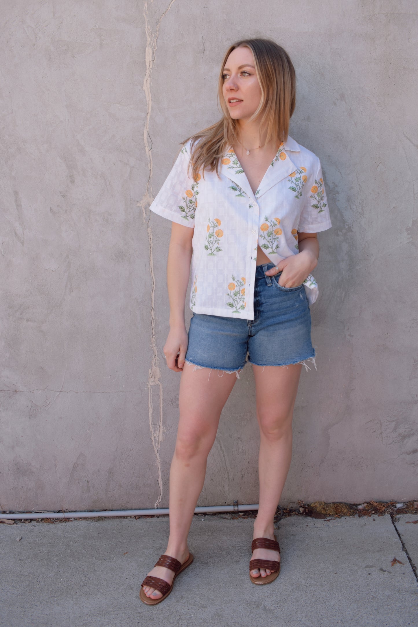 white v neck short sleeve button down with a marigold embroidered pattern. full length, straight fit. 100% cotton