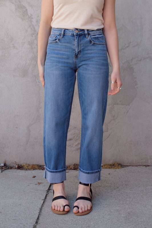 medium wash high rise stretch denim with slight barrel cut, no holes, cuffed, front and back pockets, has beltloops, zip and button enclosure