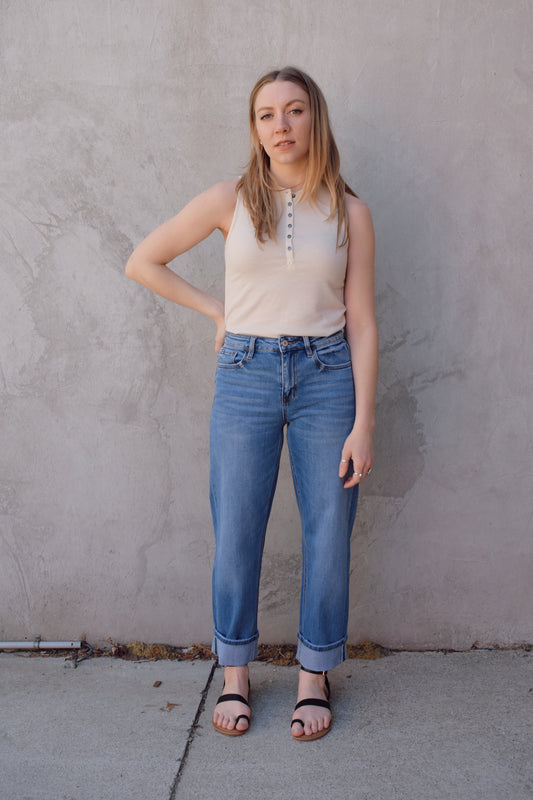 medium wash high rise stretch denim with slight barrel cut, no holes, cuffed, front and back pockets, has beltloops, zip and button enclosure