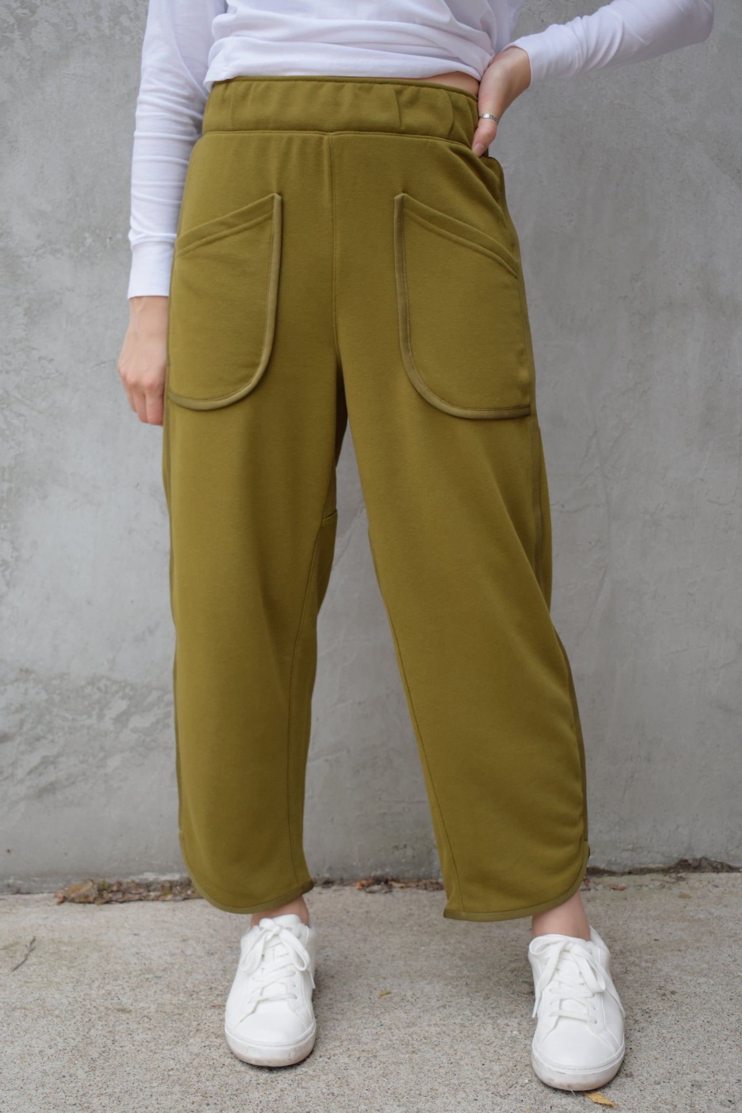 lounge pants with relaxed cropped fit, curved hem, oversized front bucket patch pockets, elastic waistband, seam detailing along sides, athleisure