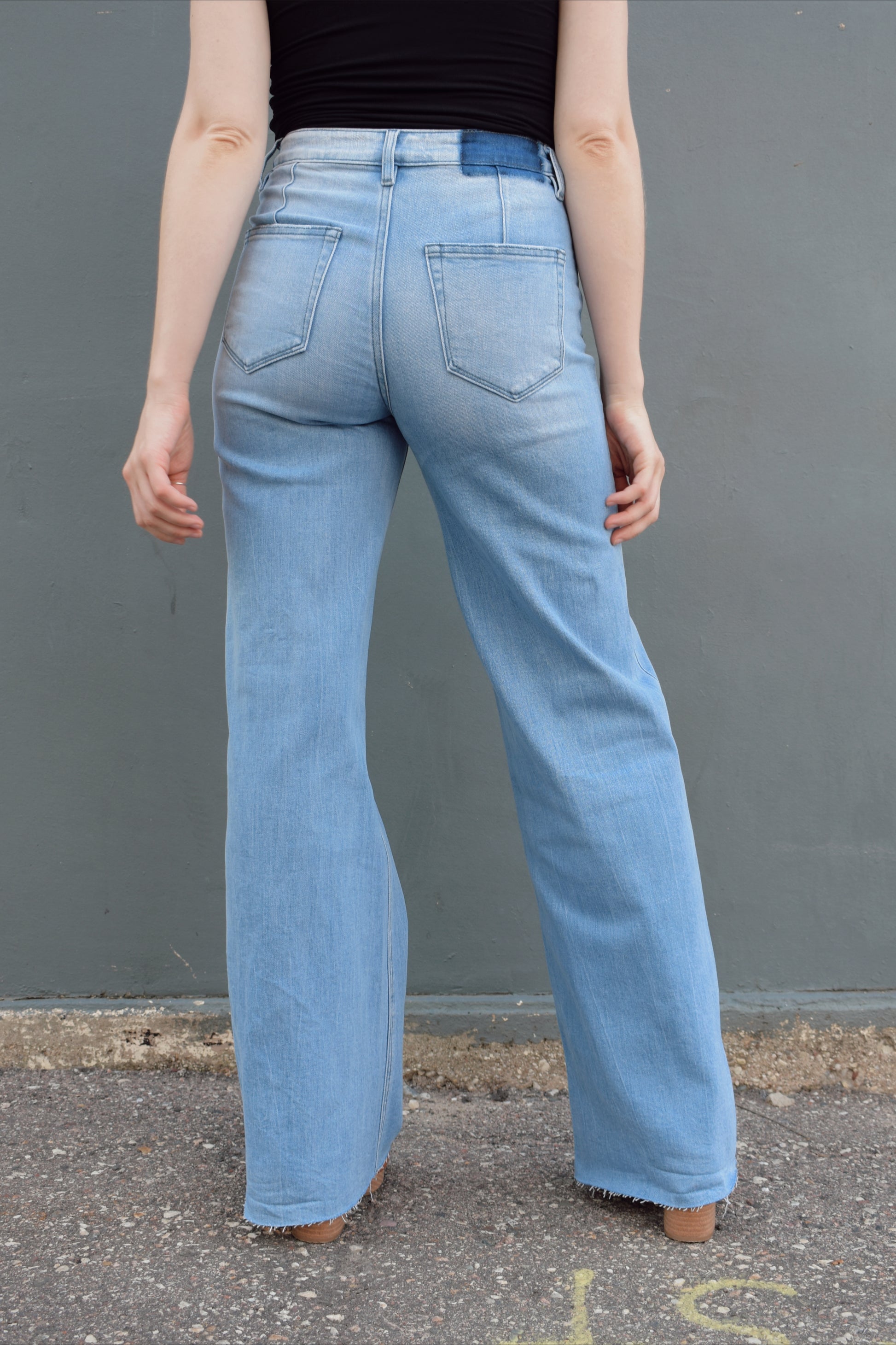 high rise full length wide leg jeans stretch denim raw hem light wash no distressing or holes, retro seam detailing above back pockets, zip and button enclosure