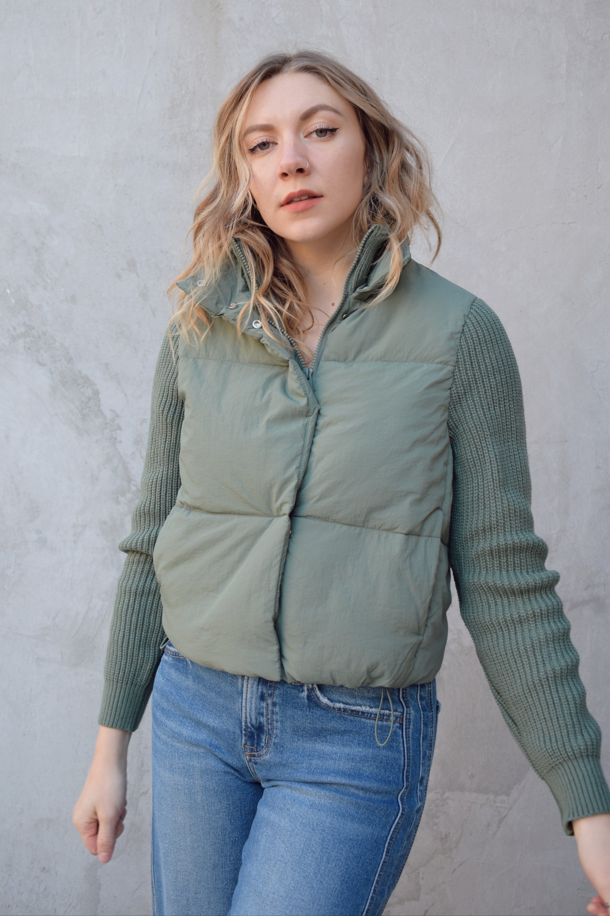 blue green puffer jacket with ribbed knit sleeves, zip and snap front enclosure, has double collar with both materials, has pockets, sinch band at hem