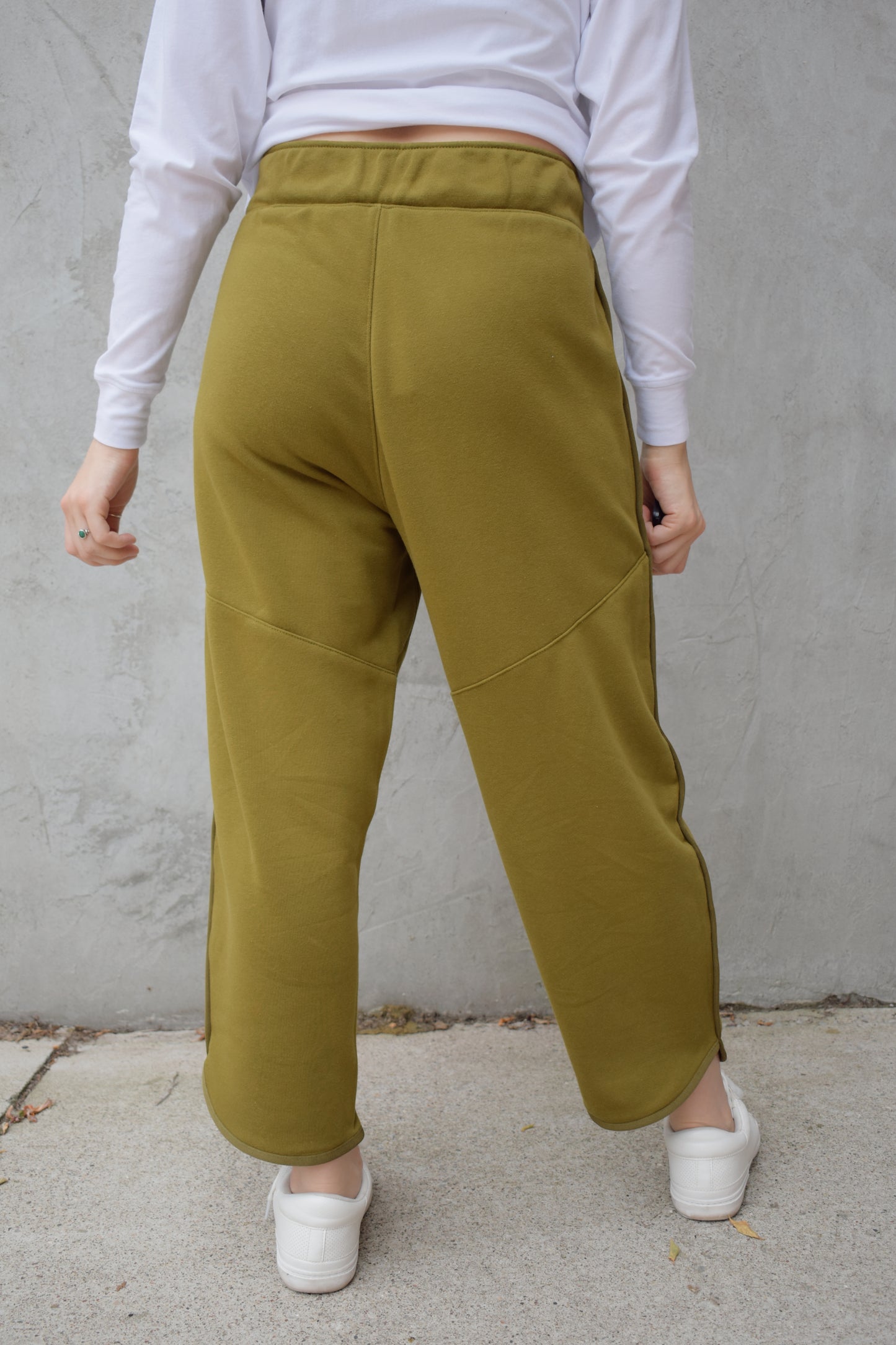 lounge pants with relaxed cropped fit, curved hem, oversized front bucket patch pockets, elastic waistband, seam detailing along sides, athleisure