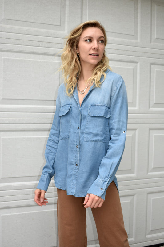  denim colored 100% tencel button down shirt. lapel collar, long camp sleeves, and front patch pockets with flaps. the brand is miss love.