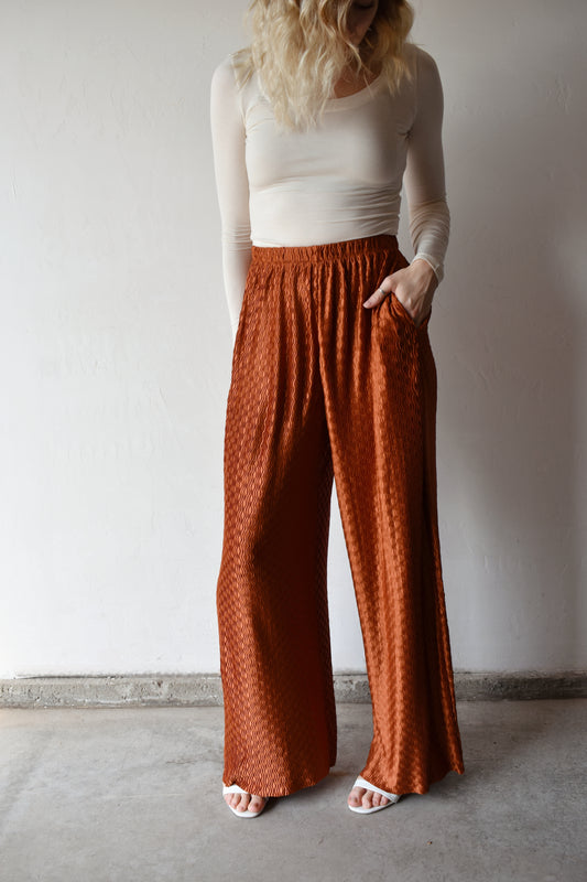 high waisted wide leg trousers with front pockets and elastic waistband. lightweight swing fabric in a copper color with textured wavy pattern. runs long.