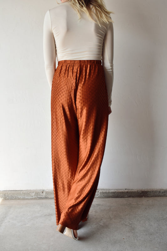 high waisted wide leg trousers with front pockets and elastic waistband. lightweight swing fabric in a copper color with textured wavy pattern. runs long.