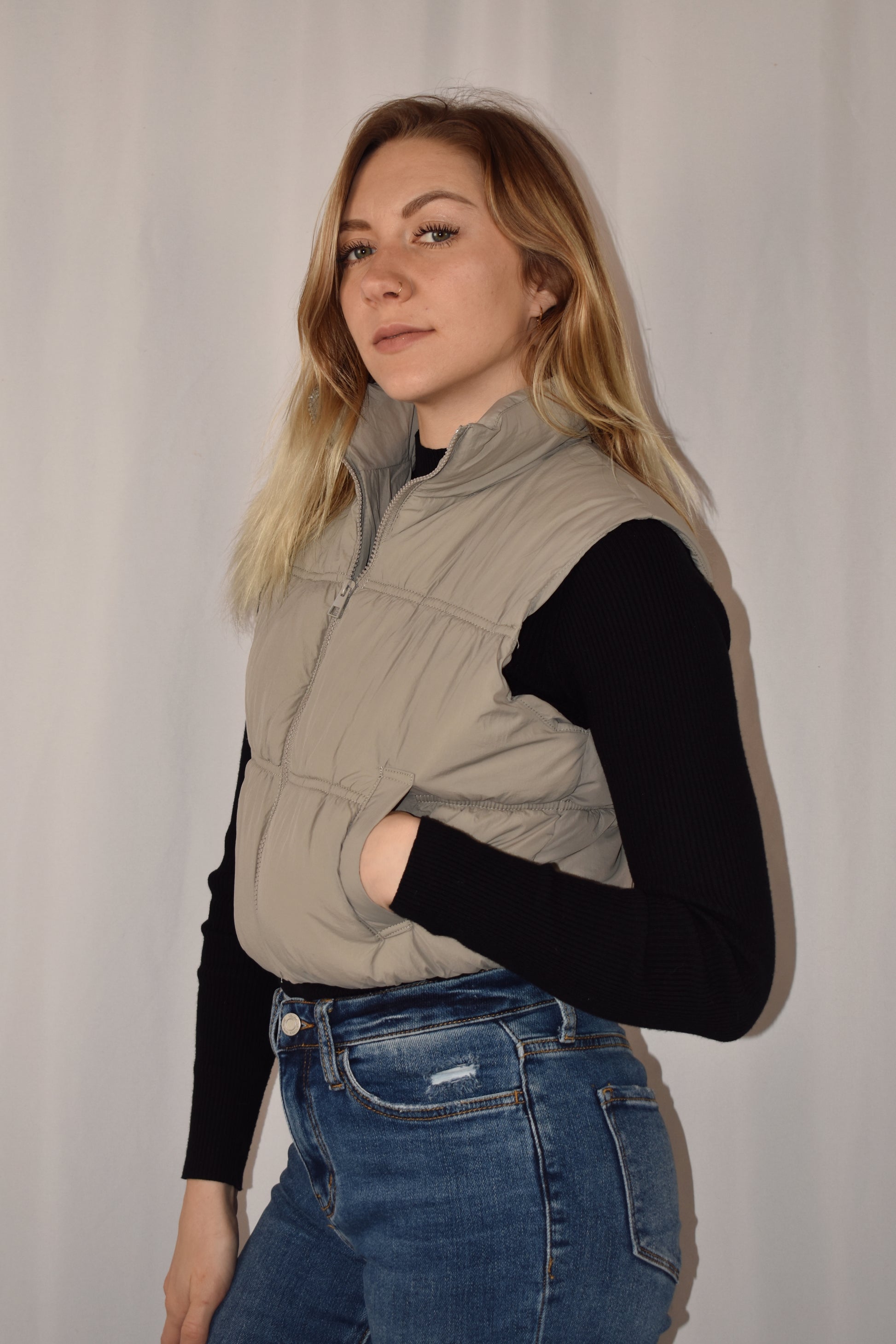 Cropped puffer vest with tight synching and side pockets. Zipper front enclosure. 