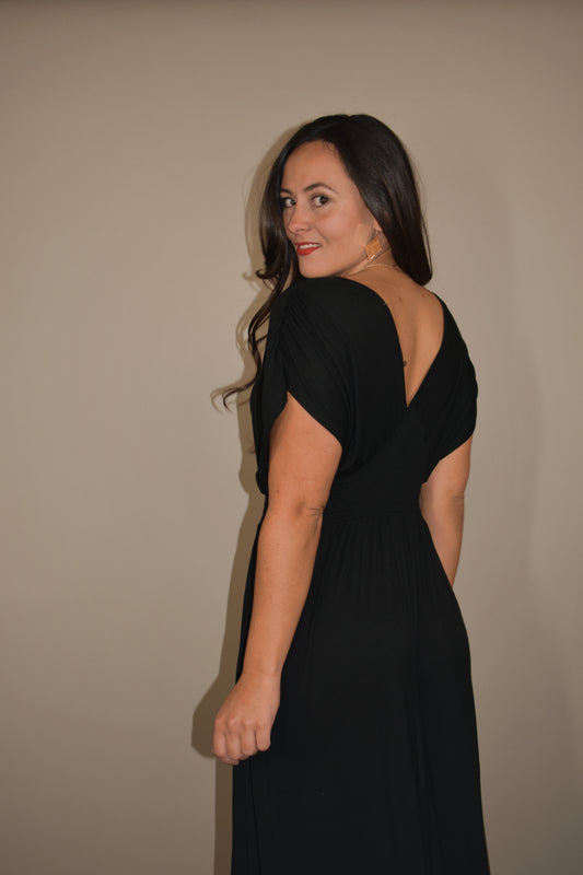 black maxi dress with lightweight flowy fabric. deep v in front and back with smocked fitted waistband. elegant cinched semi wing short sleeves