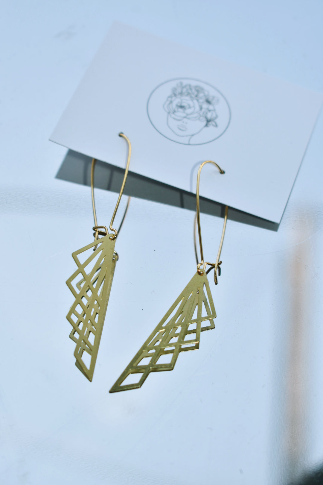 geometric laser cut brass pendants on gold plated elongated earwires edgy gold earrings