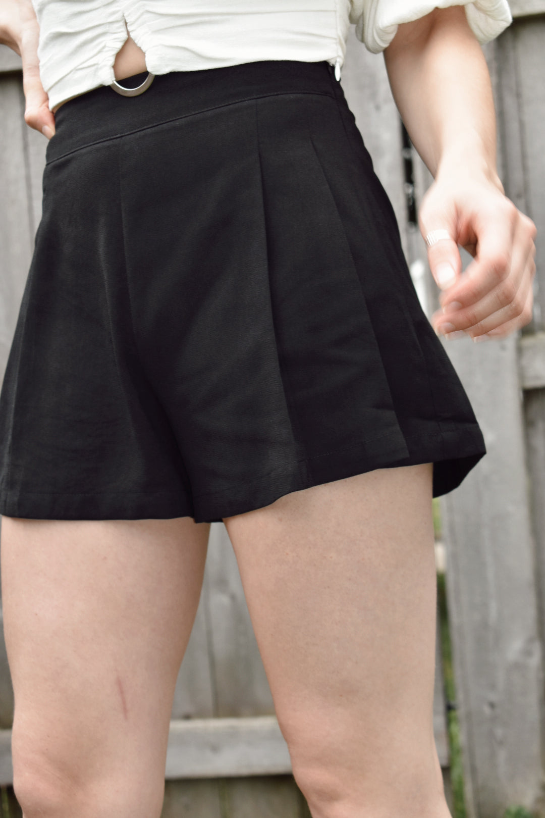 High waisted black pleated dress shorts with zipper enclosure on side fitted band on top. The brand is Mittoshop.