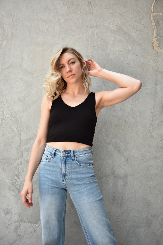Black double layered fabric cropped tank. V neck in front, scooped in back. The brand is Hyfve. 