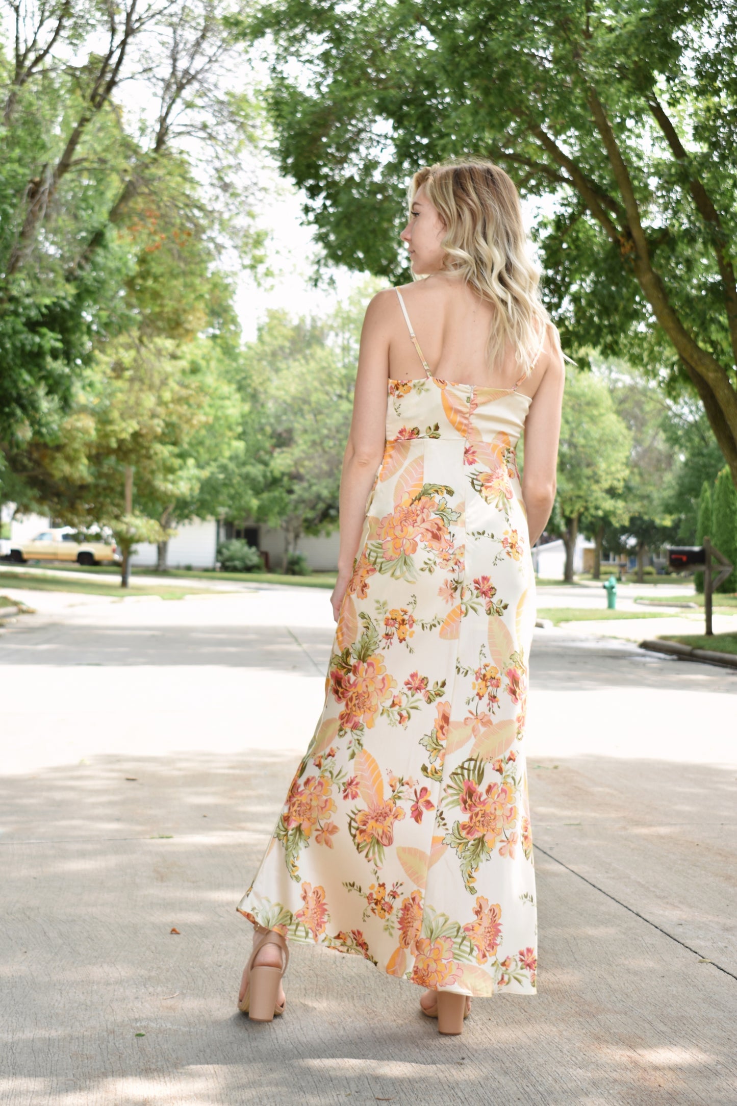 Floral printed satin midi dress with surplice neckline and adjustable spaghetti straps. Left side slit with shirred sides.