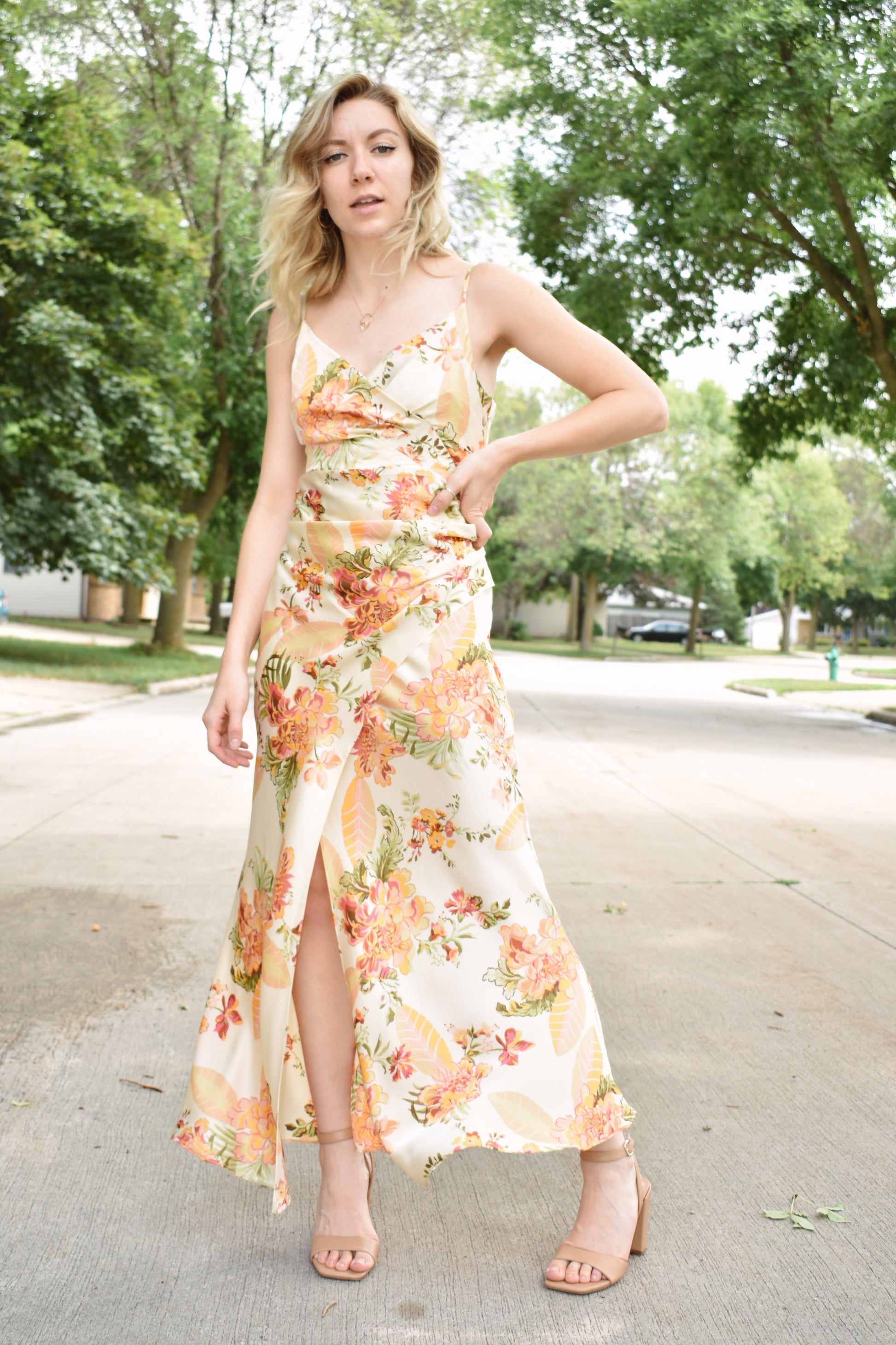 Floral printed satin midi dress with surplice neckline and adjustable spaghetti straps. Left side slit with shirred sides.