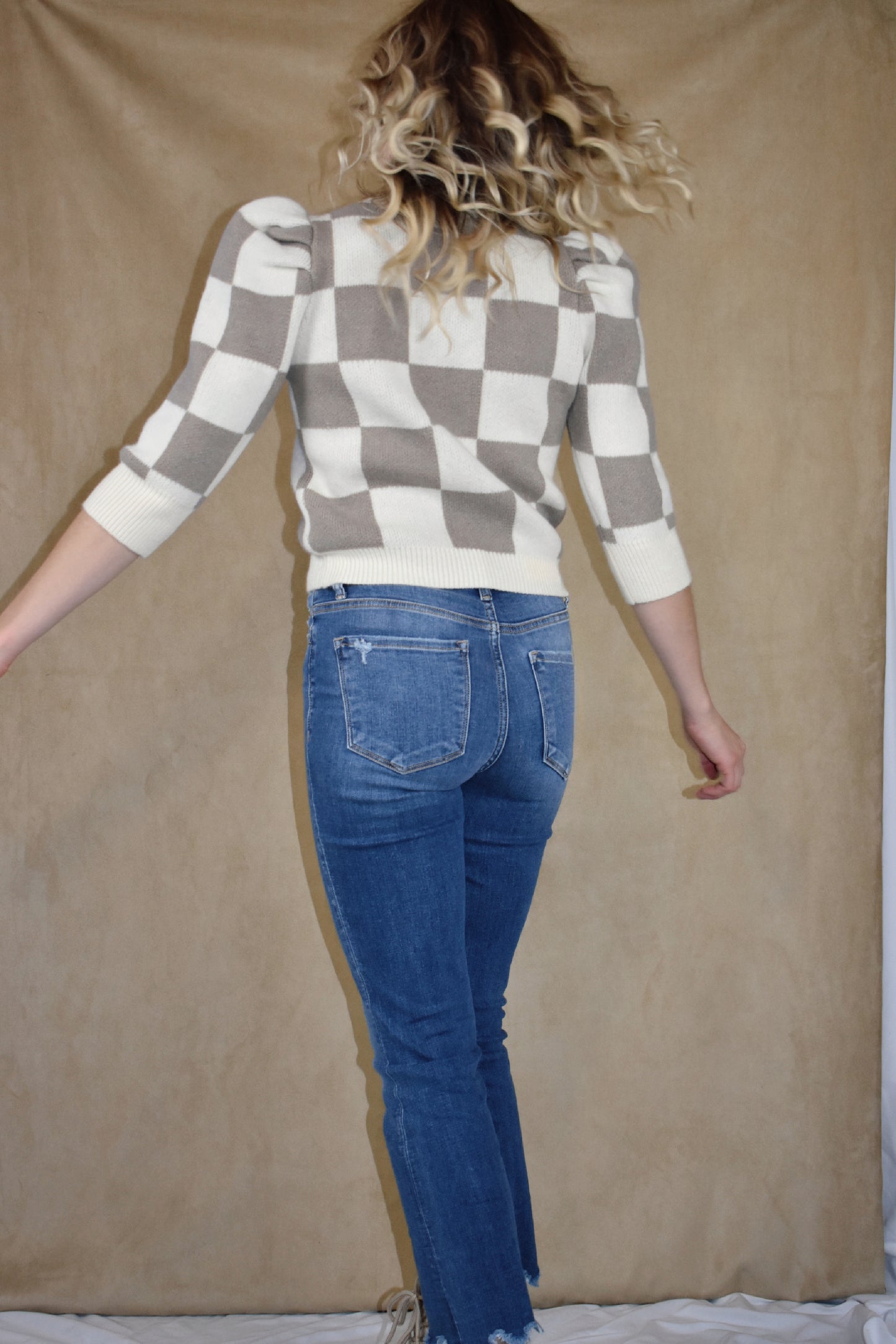 checkered ivory and taupe sweater with ribbed crew neckline, hem, and cuffs. Puff shoulders and elbow length sleeves. 