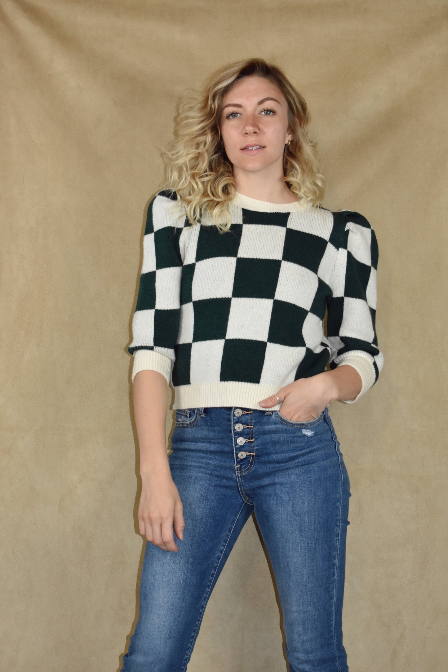 checkered green and cream sweater with ribbed crew neckline, hem, and cuffs. Puff shoulders and elbow length sleeves. 
