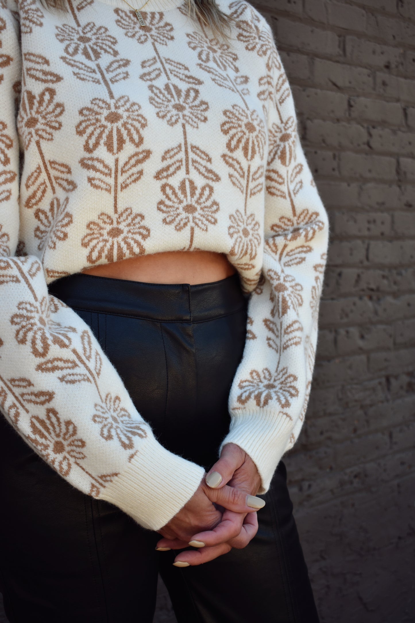 taupe and cream floral pattern knit sweater with ribbed high round neckline, hem, and cuffs. 