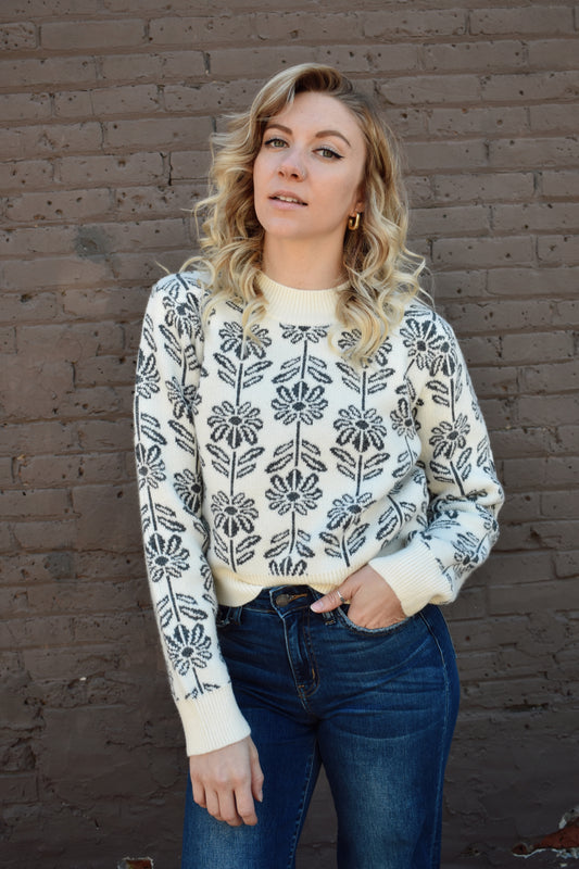 charcoal and cream floral pattern knit sweater with ribbed high round neckline, hem, and cuffs. 
