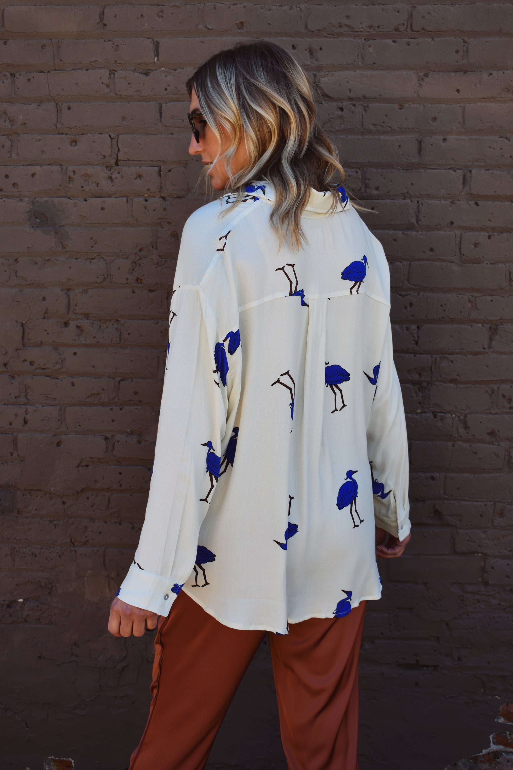 White relaxed fit button down with blue birds printed on it. High low hem. Drop shoulders.