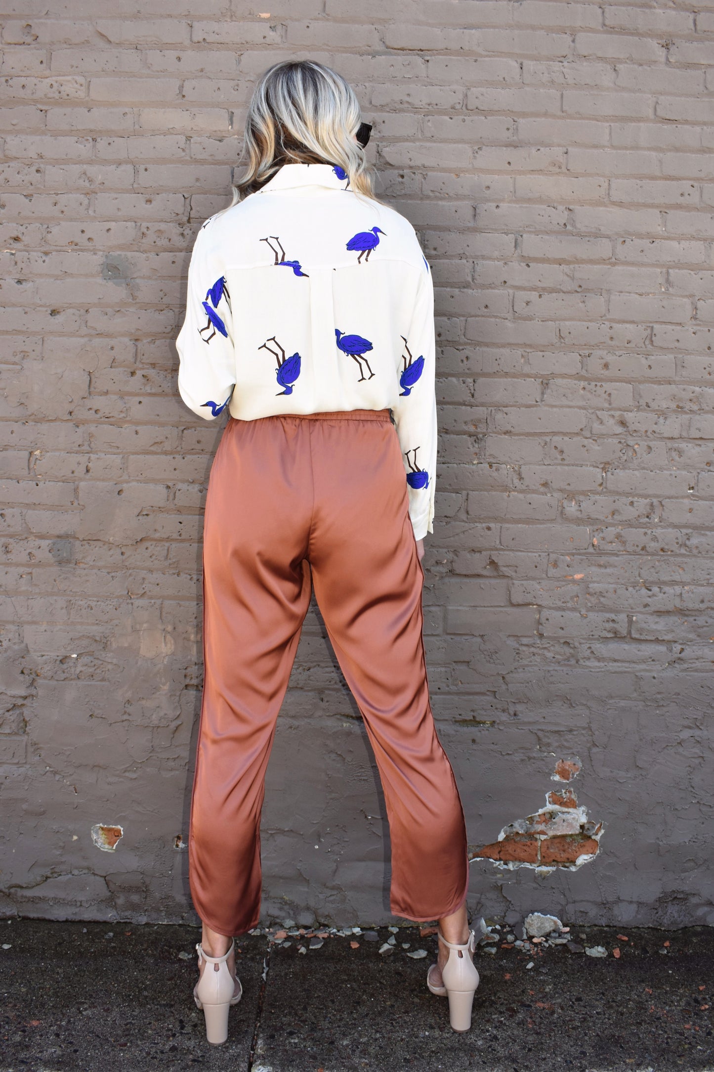 Copper colored satin joggers with side pockets and elastic waistband. rounded tulip hem with welted side seams.