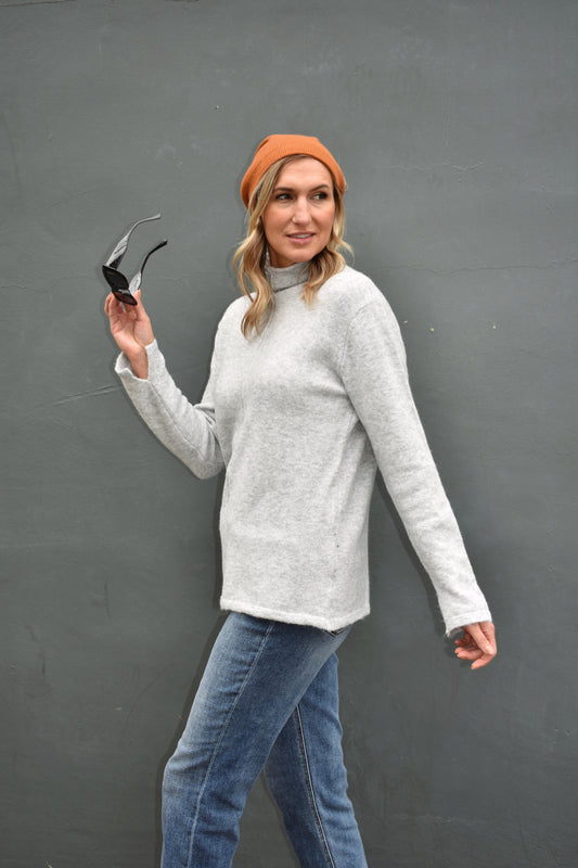 heather grey mock neck full length sweater with raw hem detail down the front. lightweight and soft fabric. 