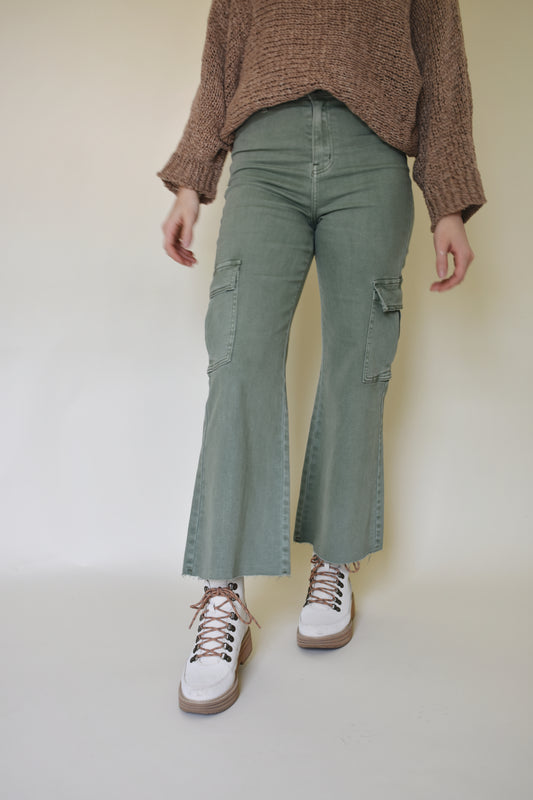 Wide leg cargo pants with pockets on side with flap and on the back. Button enclosure with belt loops. Raw hem. Sage green color. 