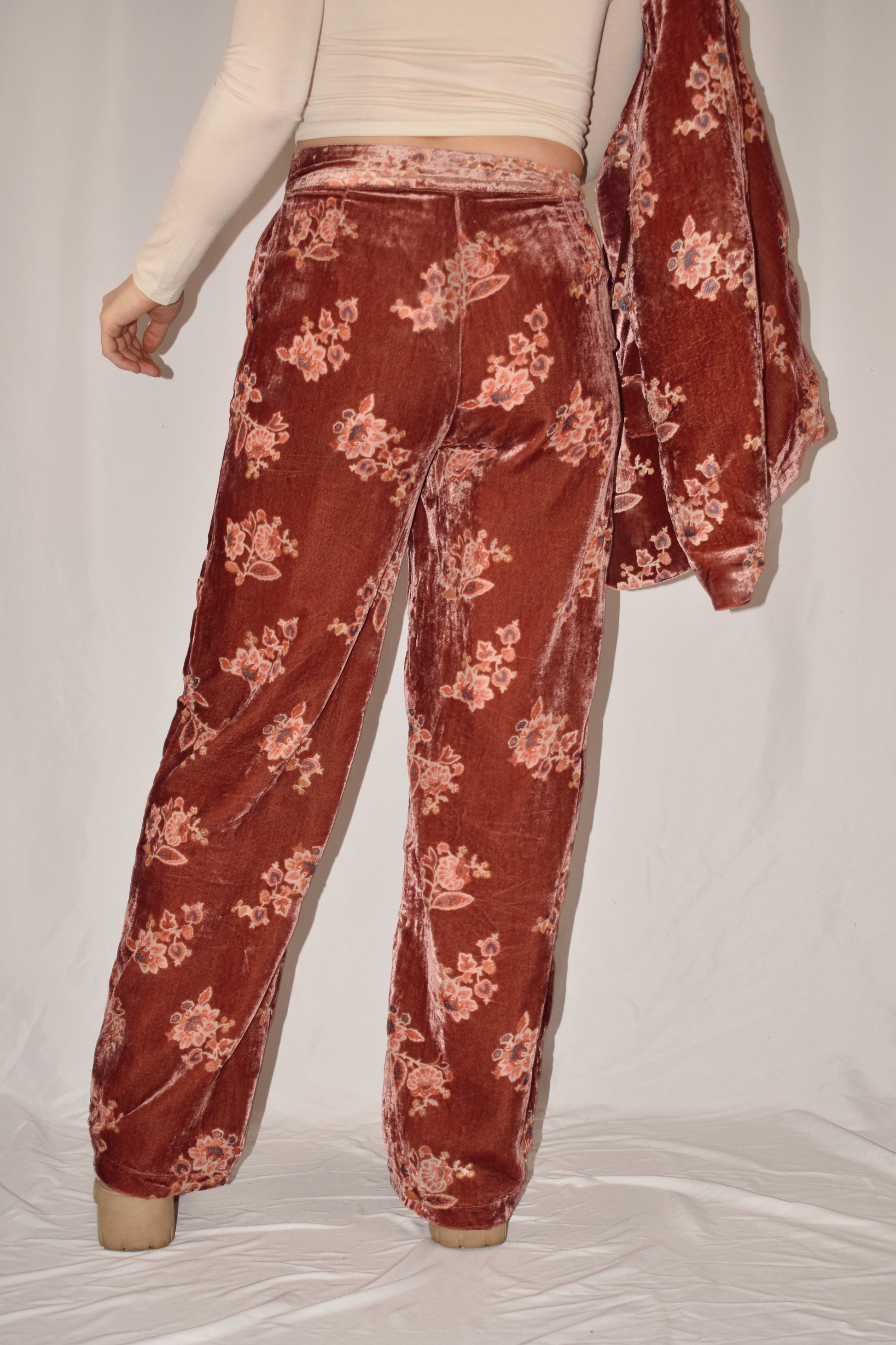 Mauve velvet straight leg trousers with side pockets and zip and button front enclosure. floral pattern. full length.